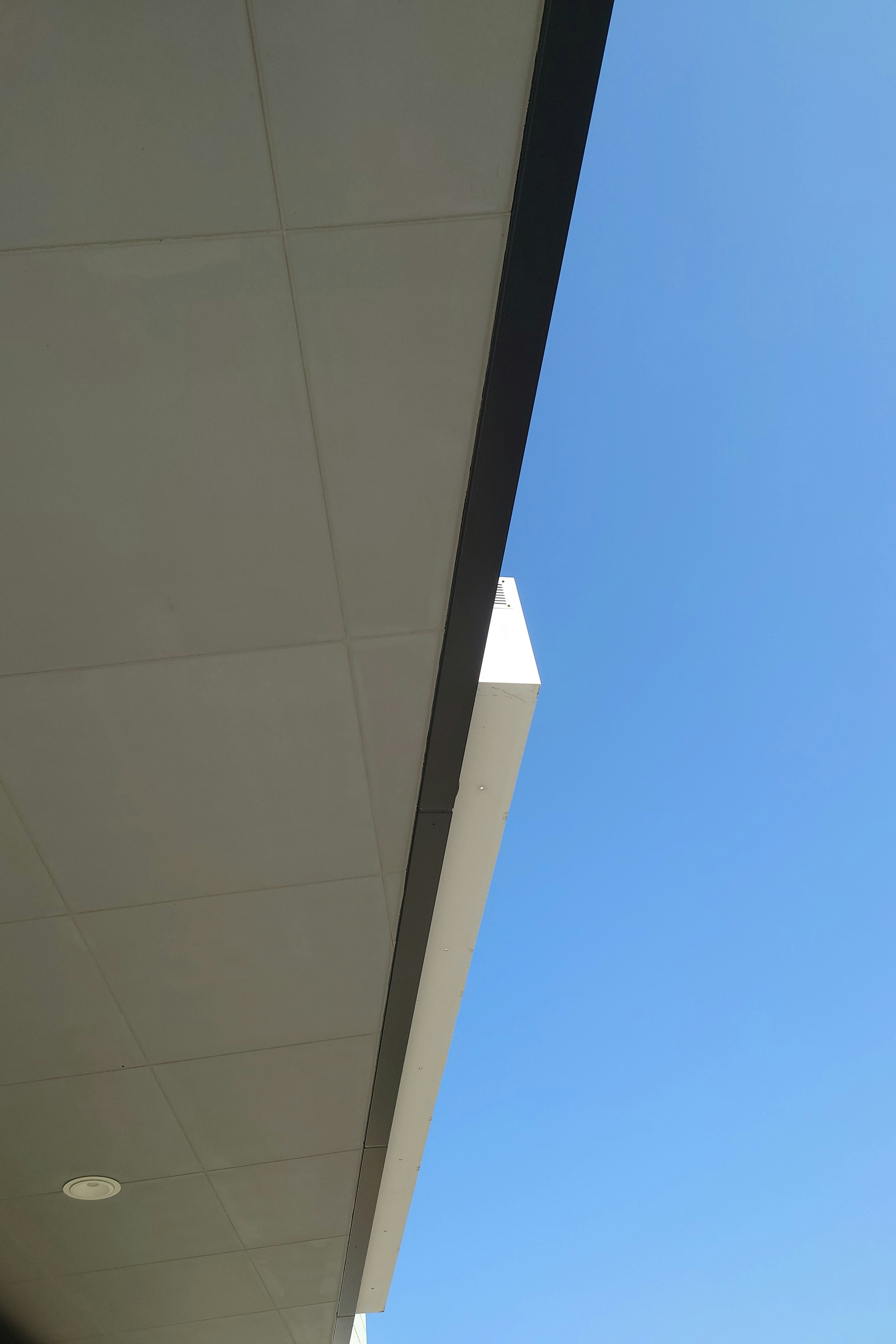 Image montrant une partie d'un bâtiment contre un ciel bleu clair