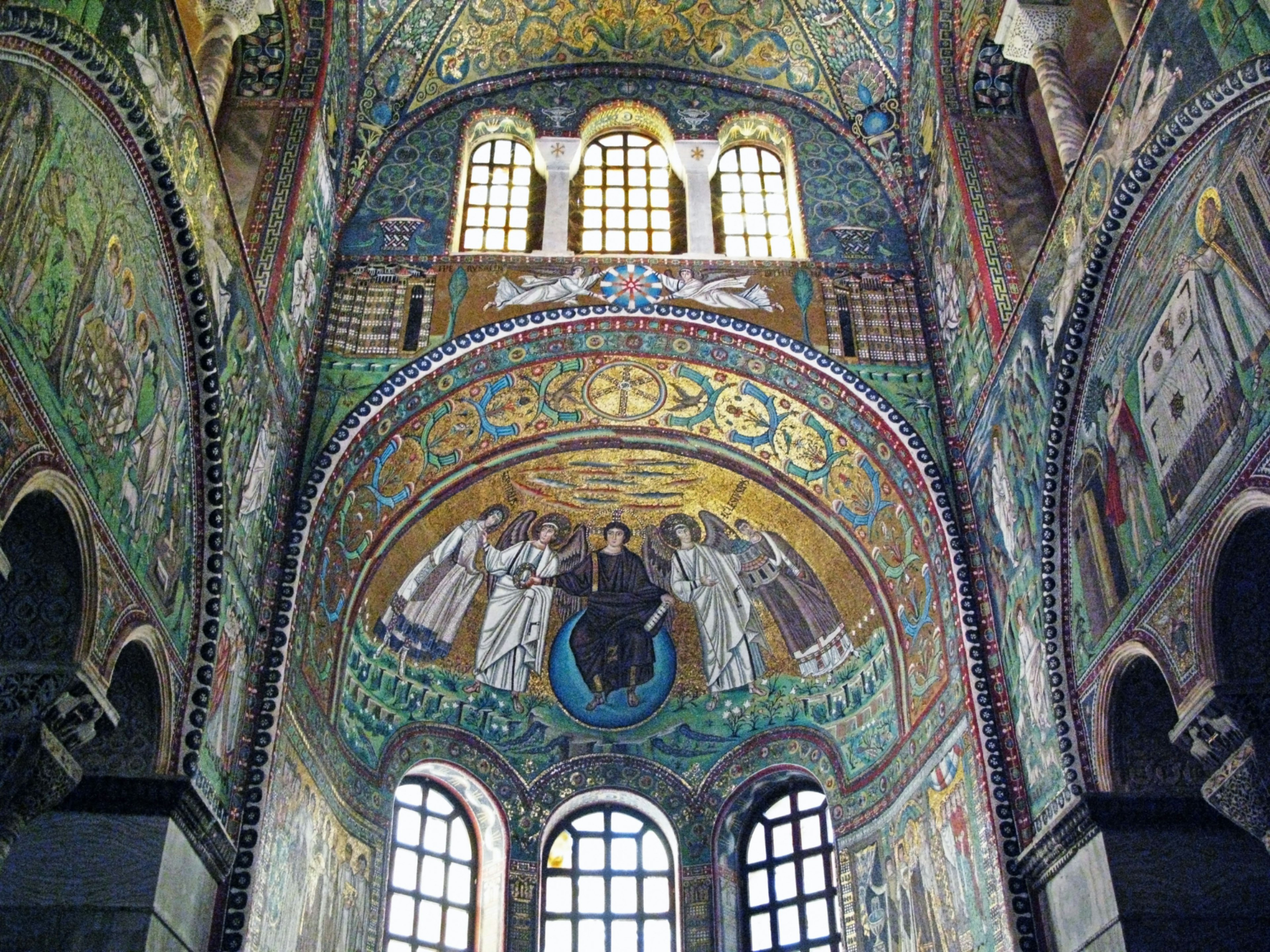 Innenansicht einer Kirche mit beeindruckenden Mosaiken und religiösen Gemälden an Wänden und Decke