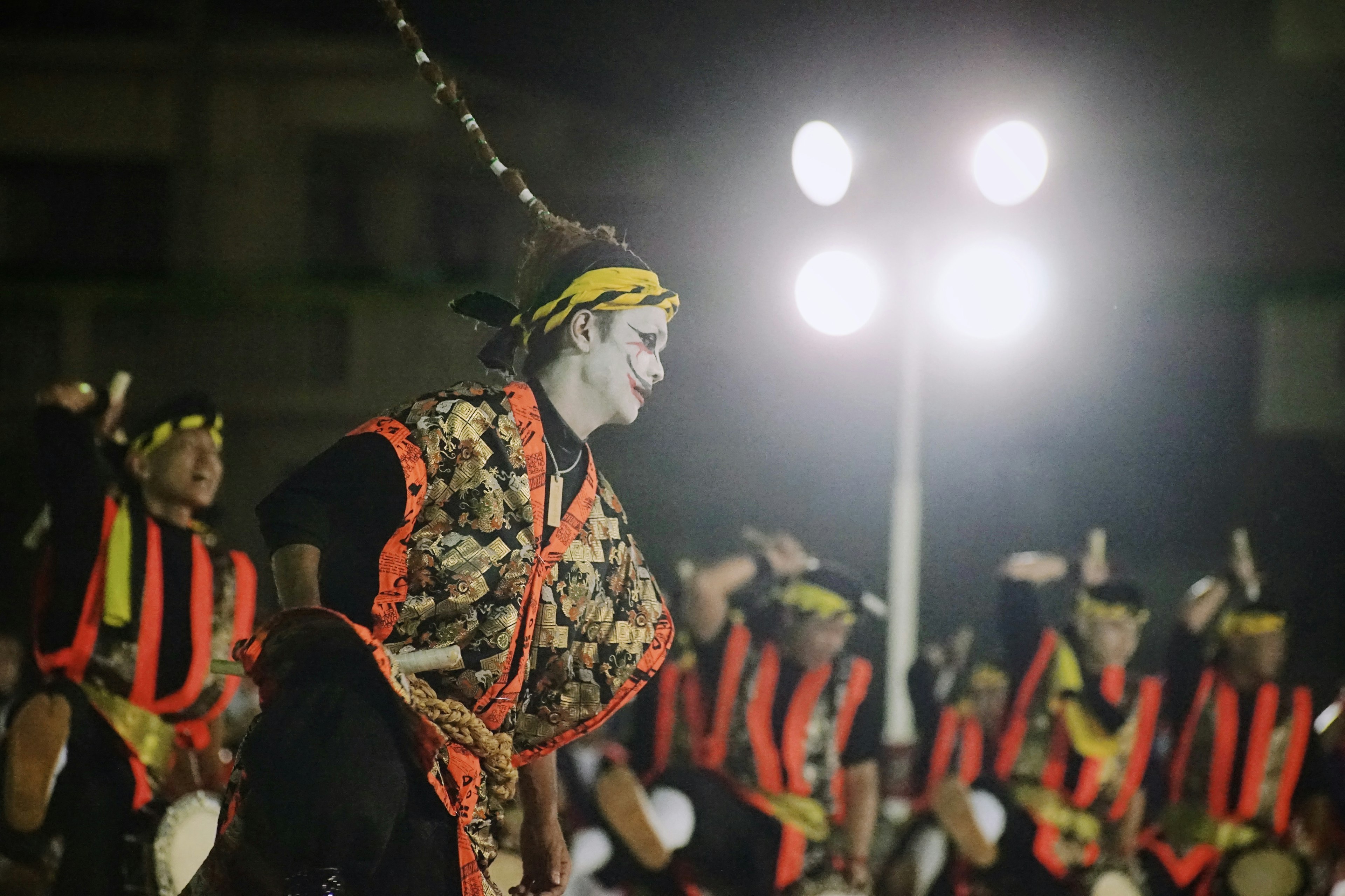 Darsteller in traditionellen Kostümen, die bei einem Nachtfest tanzen