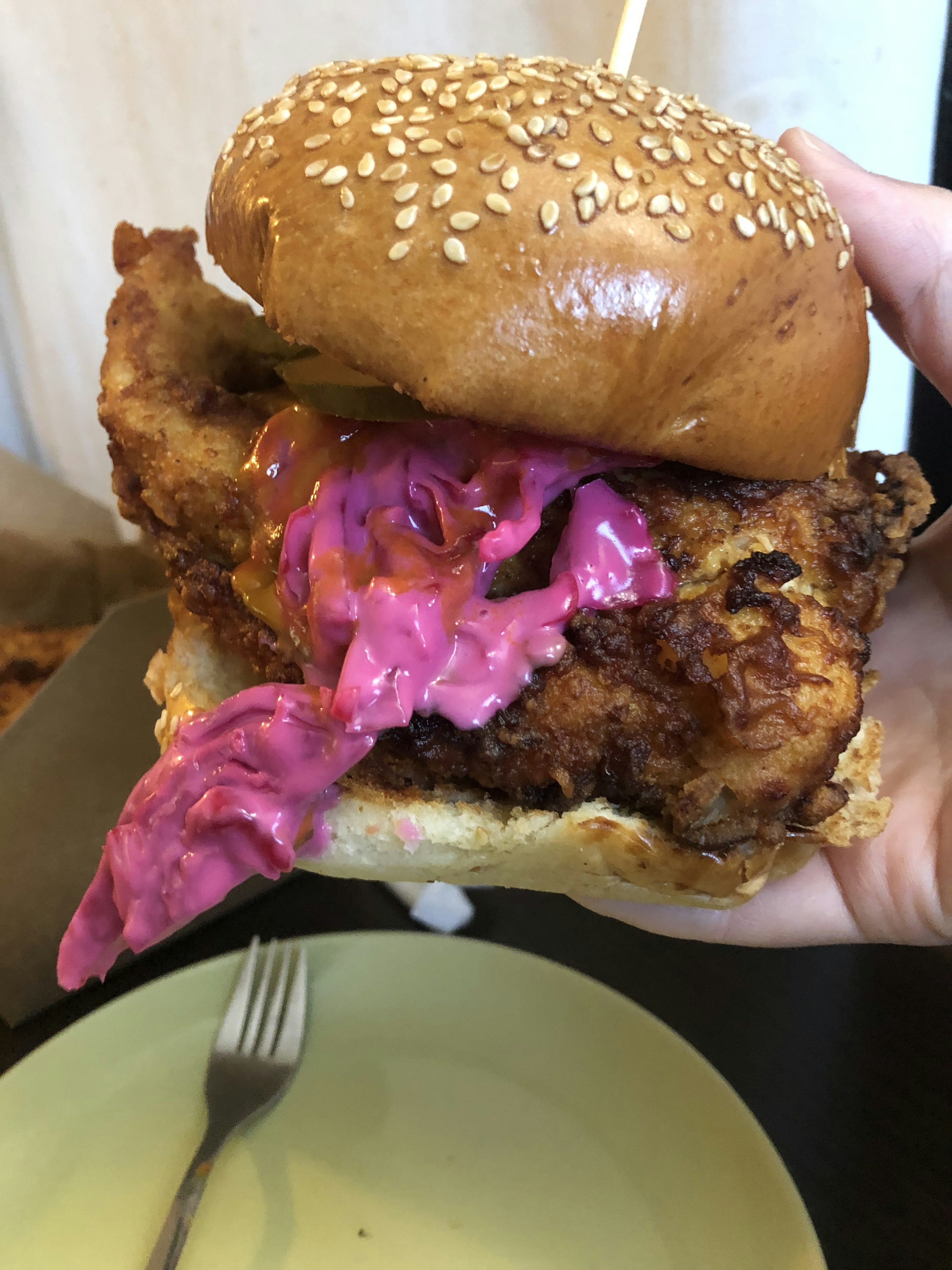 Crispy fried chicken sandwich with pink cabbage in a sesame bun