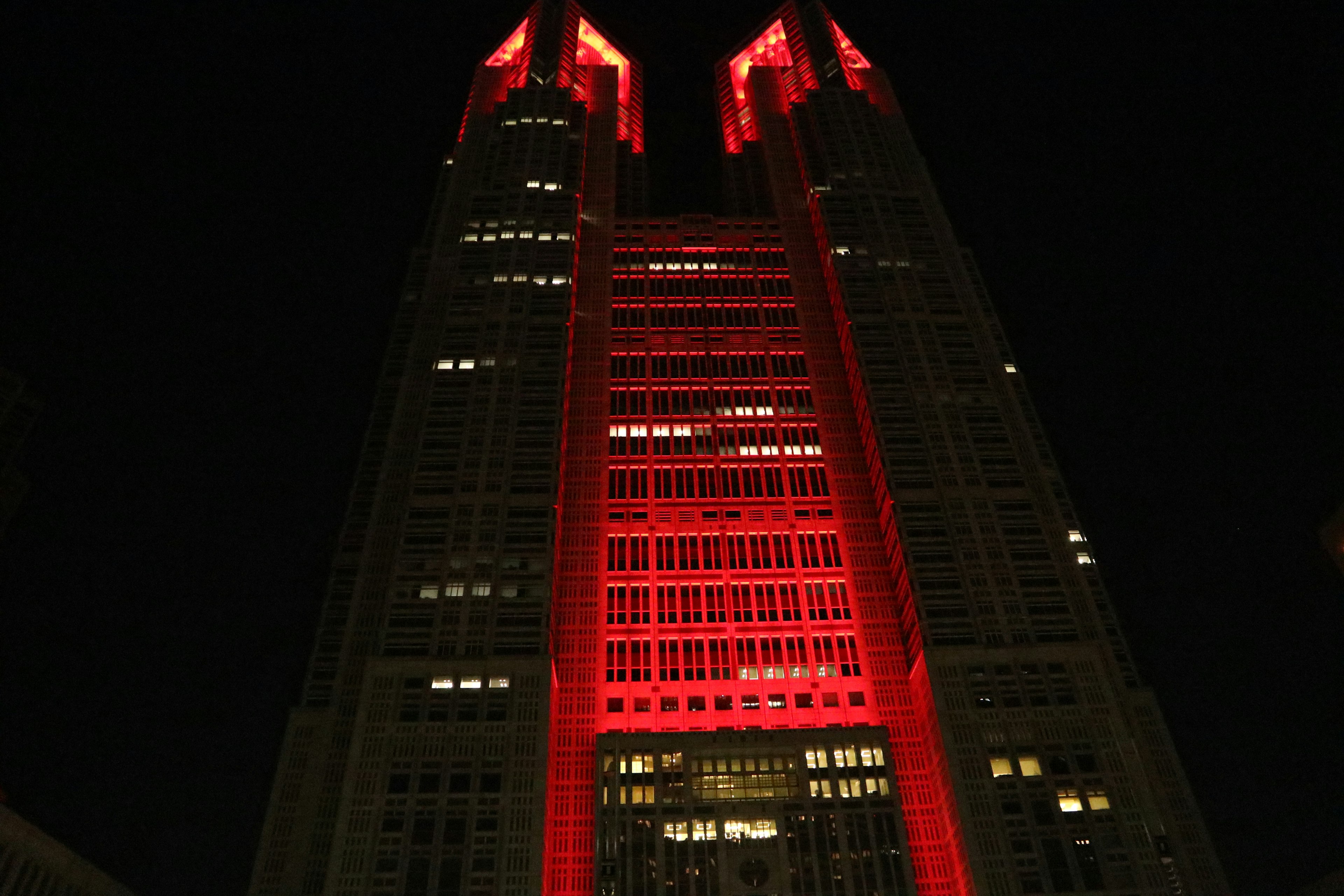 In Rot beleuchteter Wolkenkratzer in Tokio bei Nacht