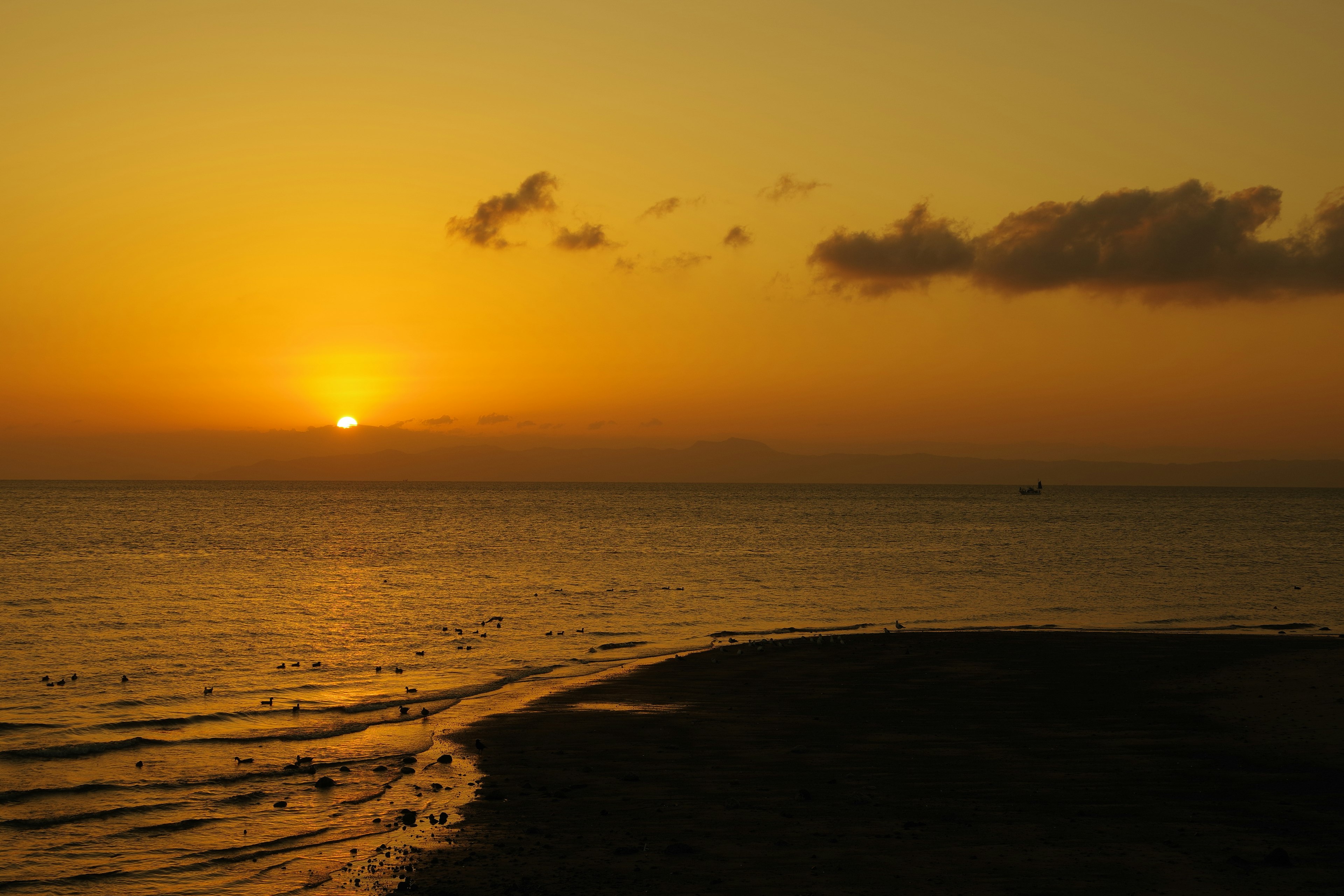 Beautiful sunset over the ocean orange sky and calm waves