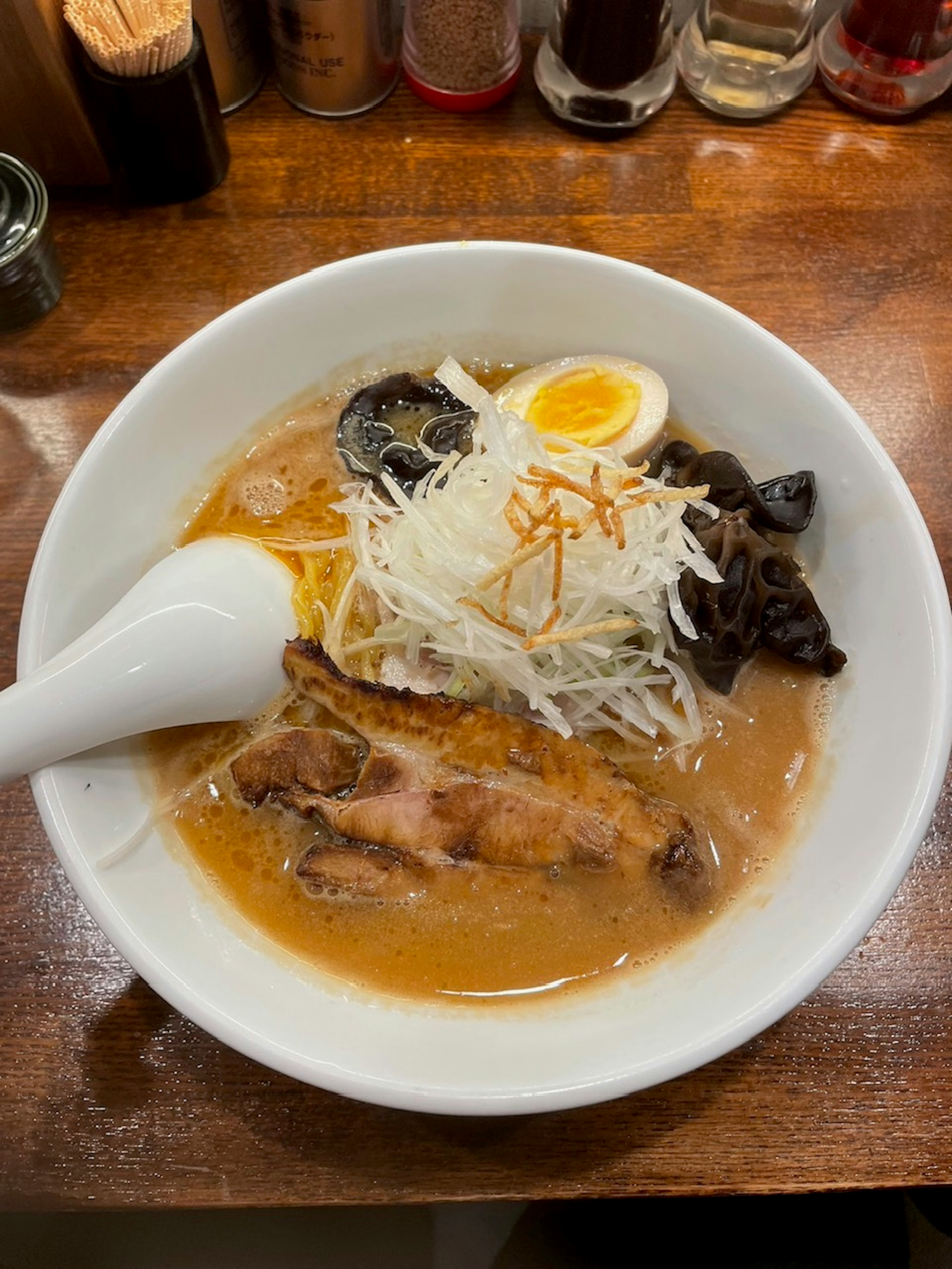 Ramen bowl with broth, chashu, soft-boiled egg, bean sprouts, and wood ear mushrooms