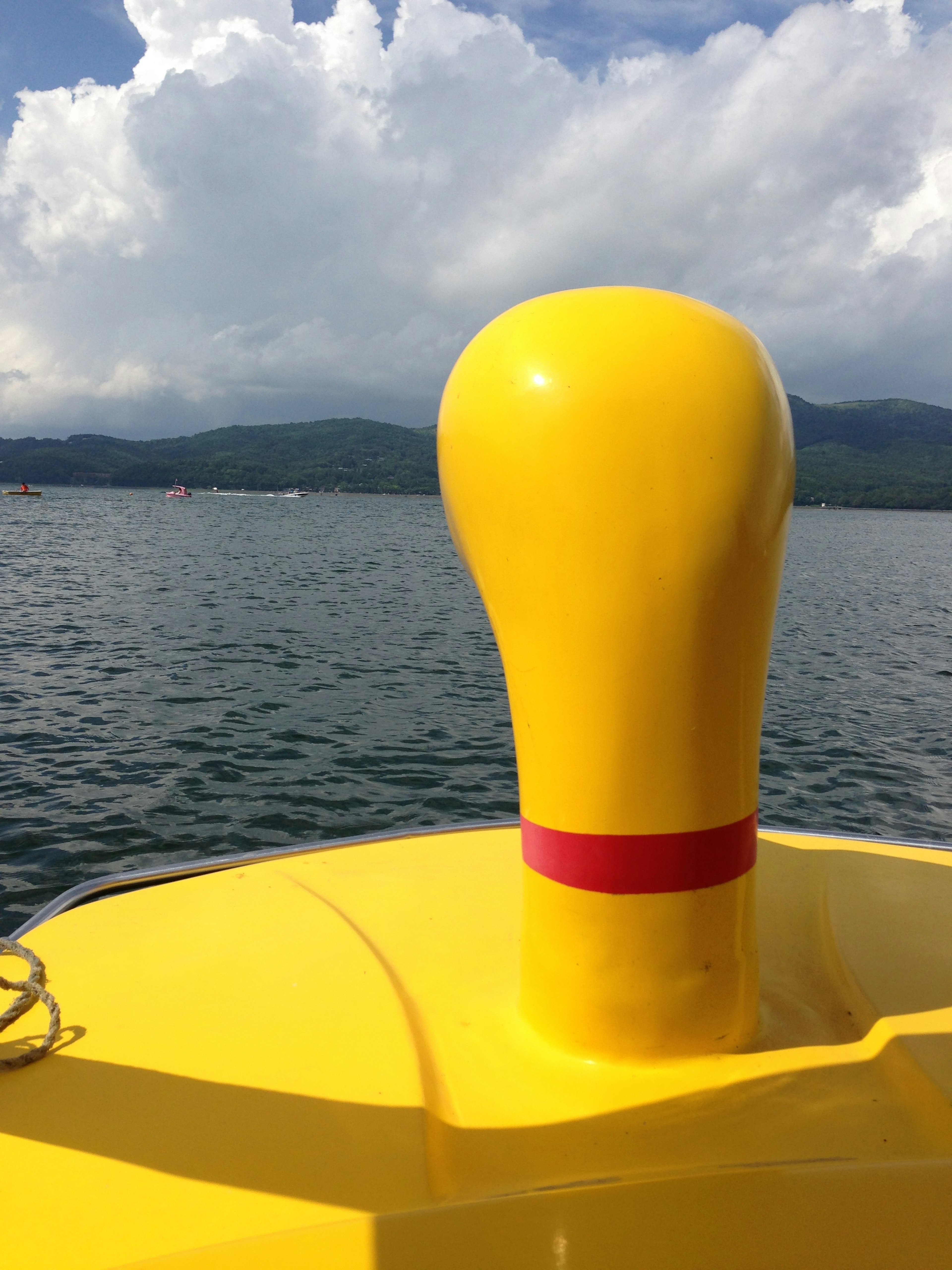 Yellow buoy with a red stripe against a serene water background