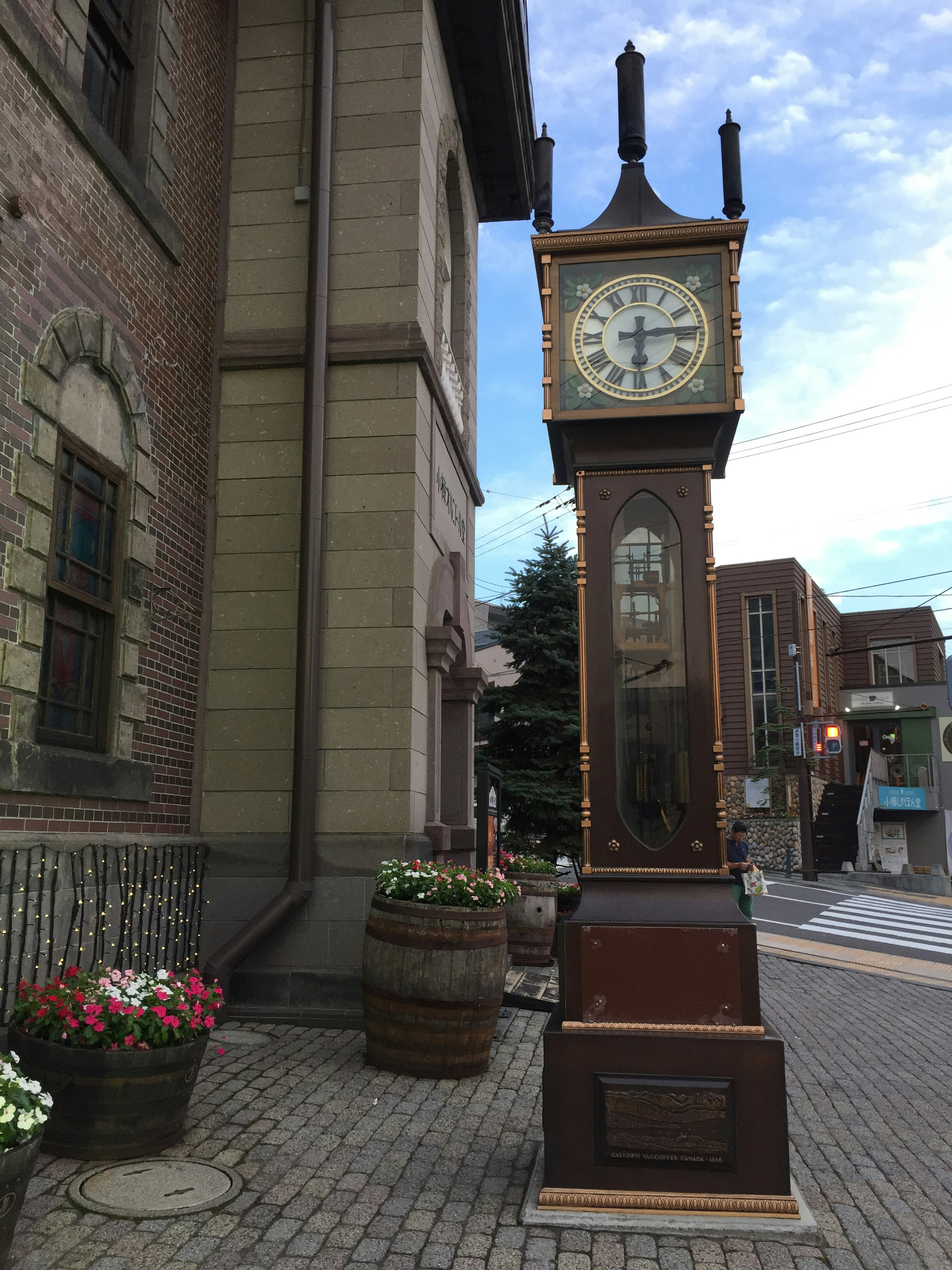 Street corner featuring a clock tower and flower pots near a building