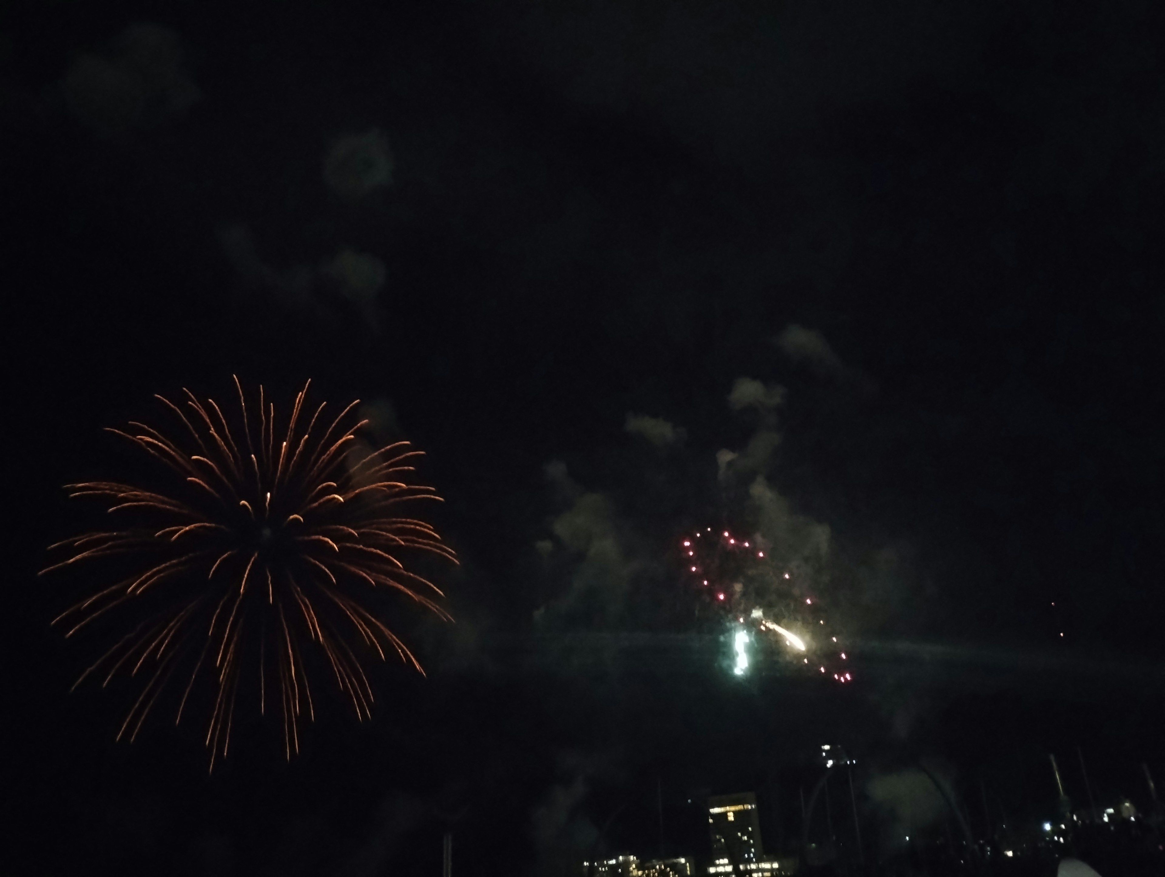 Fuegos artificiales vibrantes estallando en el cielo nocturno con estelas coloridas