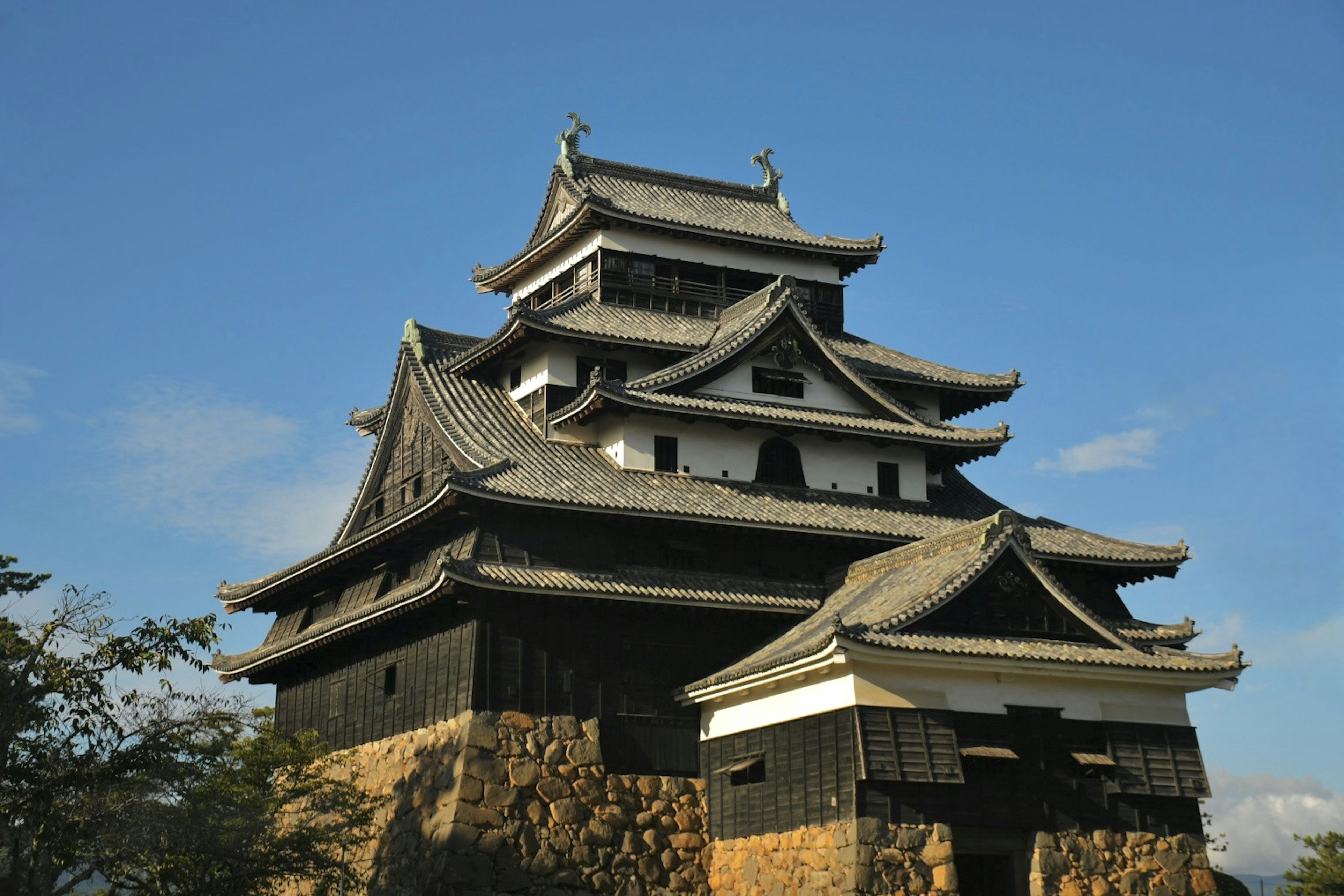 黒い石垣の上に立つ日本の城の美しい建築