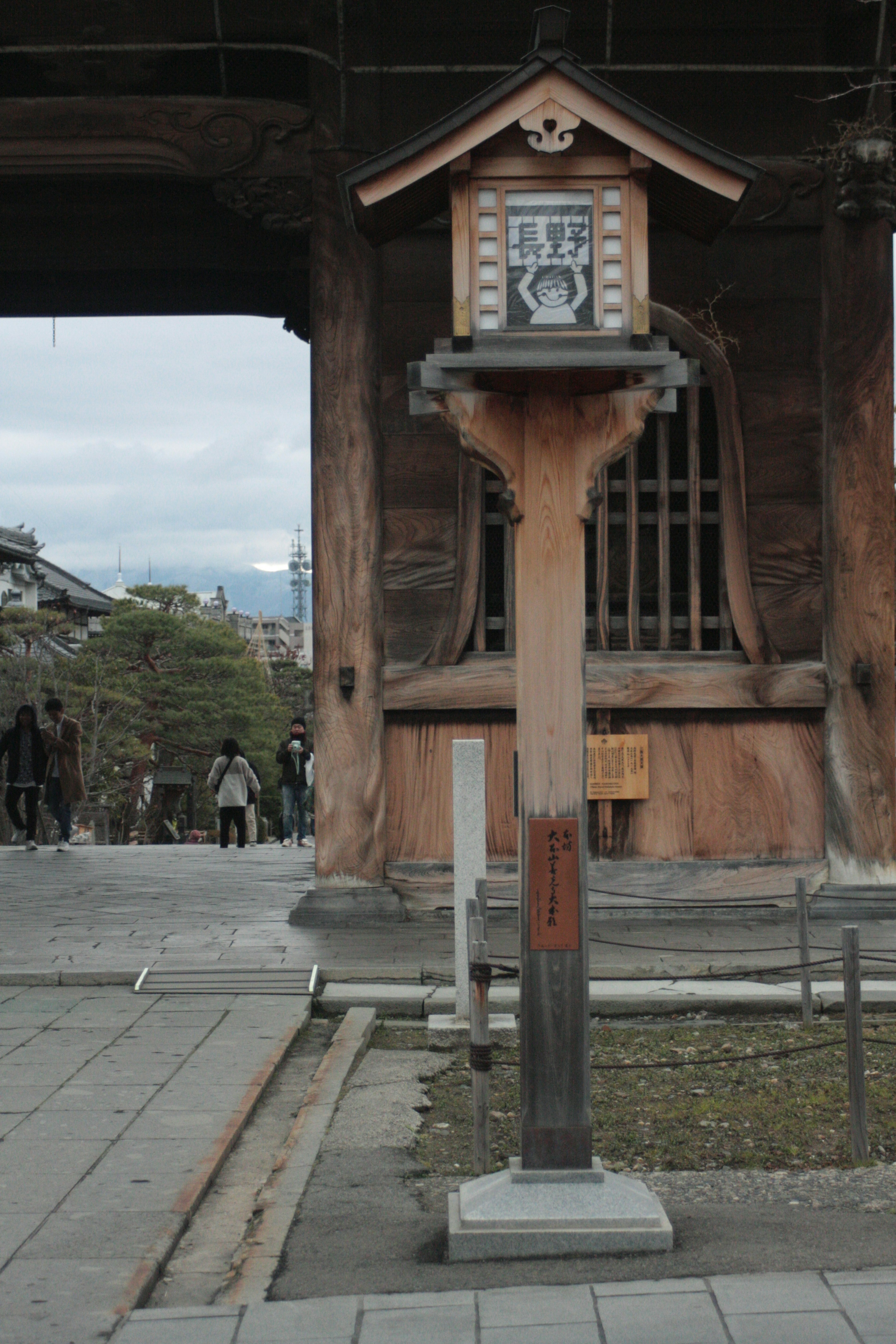 Horloge traditionnelle montée sur un poteau en bois avec un paysage environnant