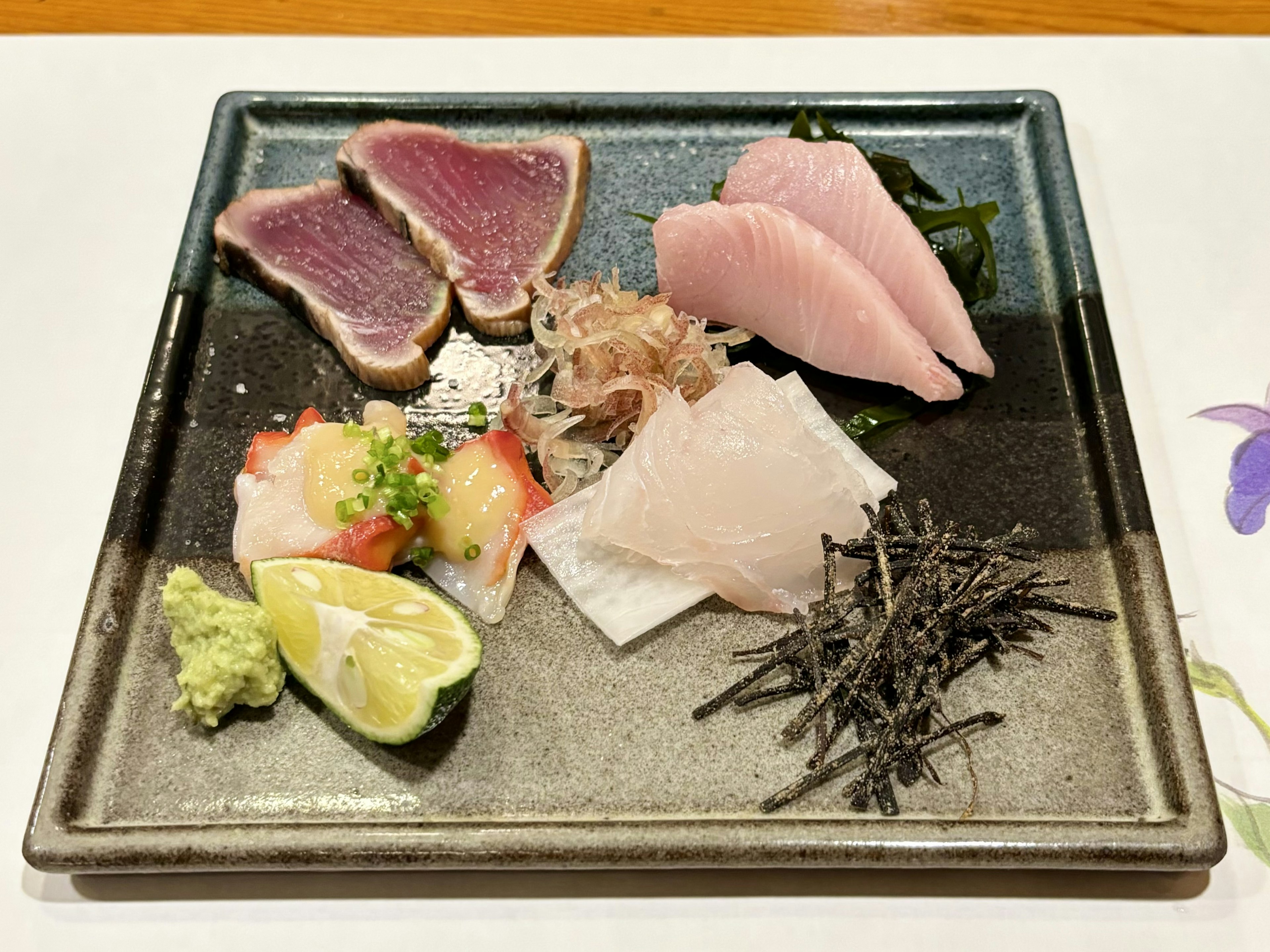 A beautiful plate featuring an assortment of fresh sashimi including tuna and garnishes