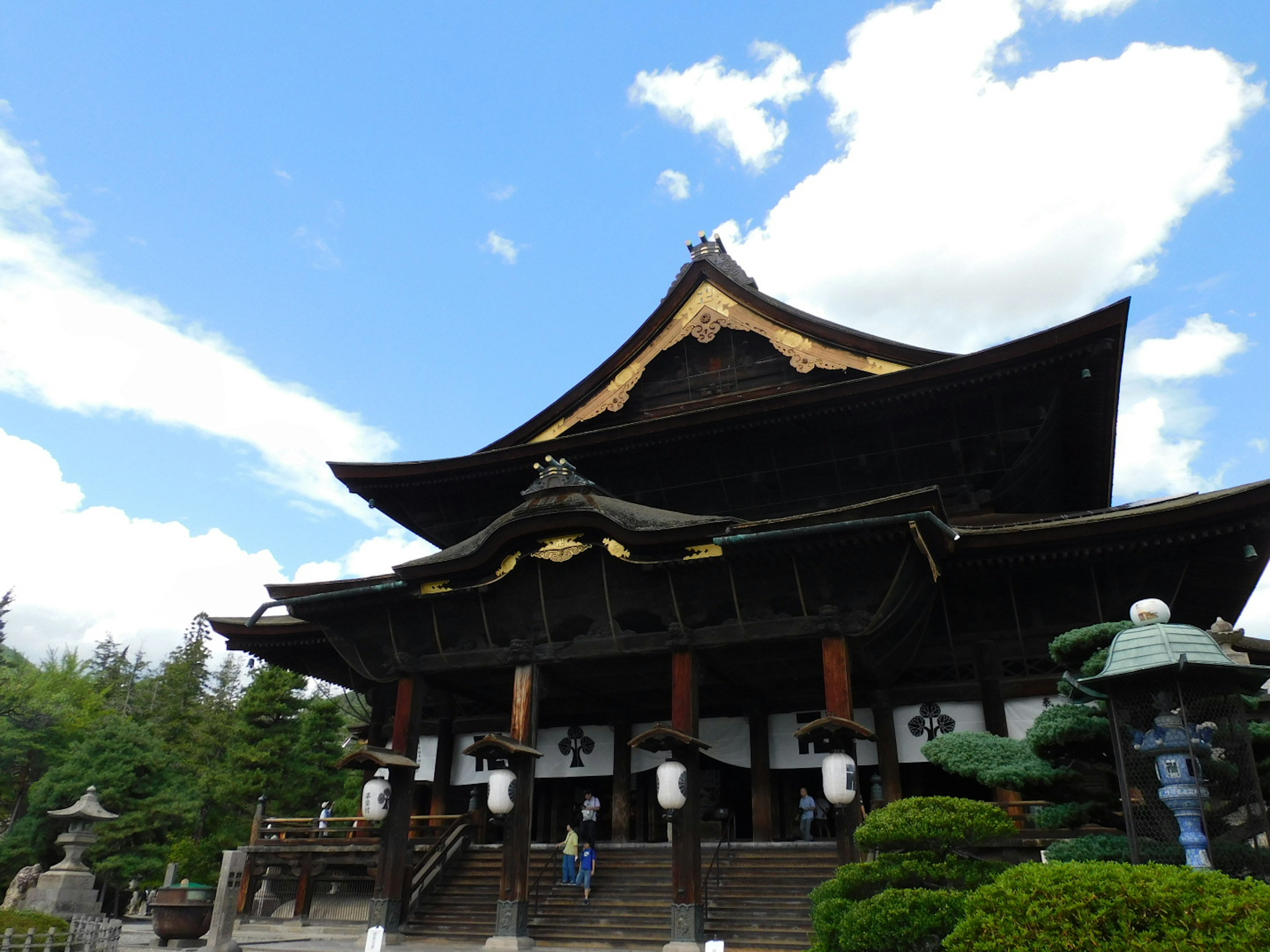 Bel extérieur d'un temple japonais entouré de jardins verts et d'un ciel bleu