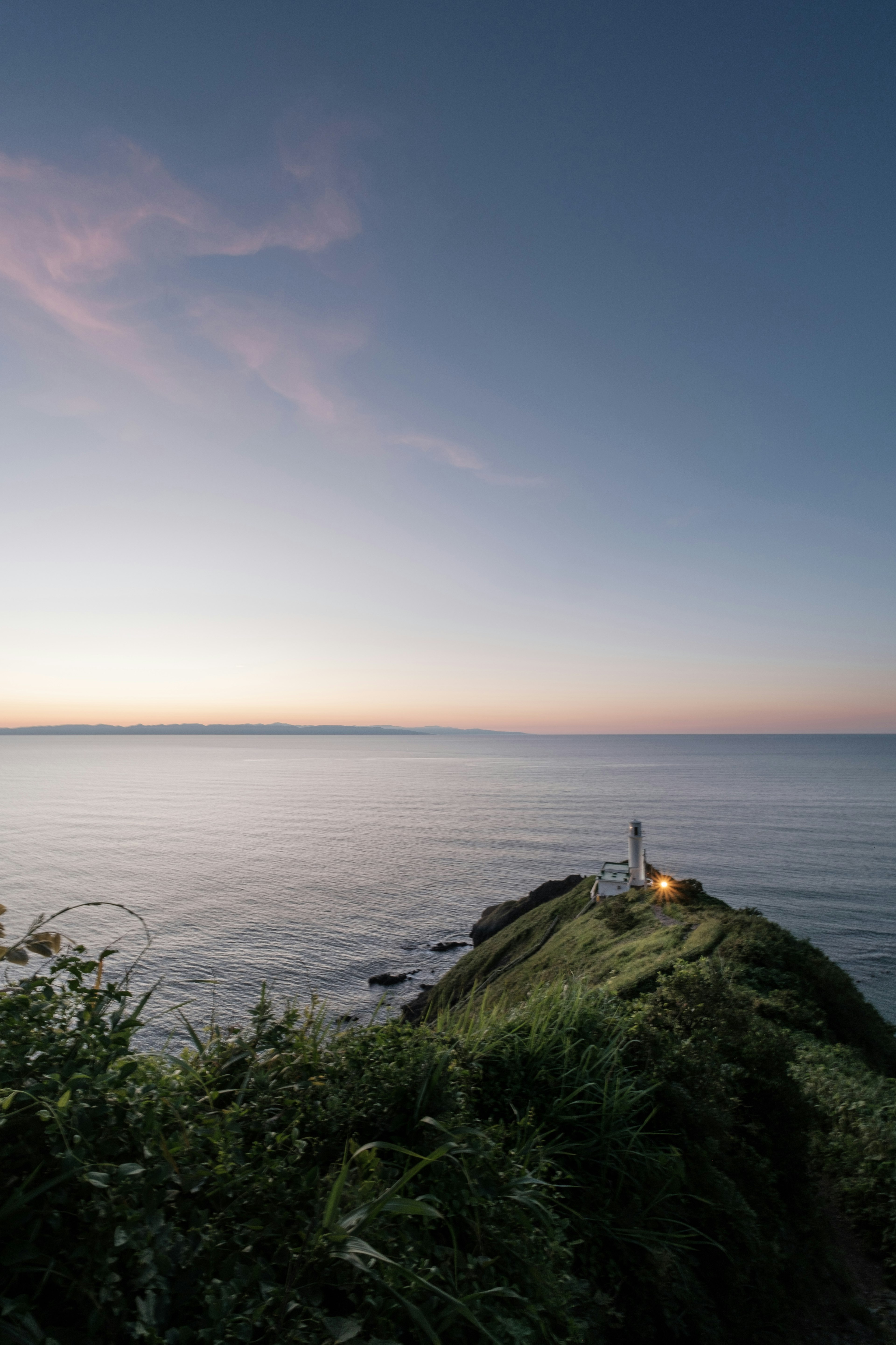 静かな海の近くに立つ人と穏やかな空の風景