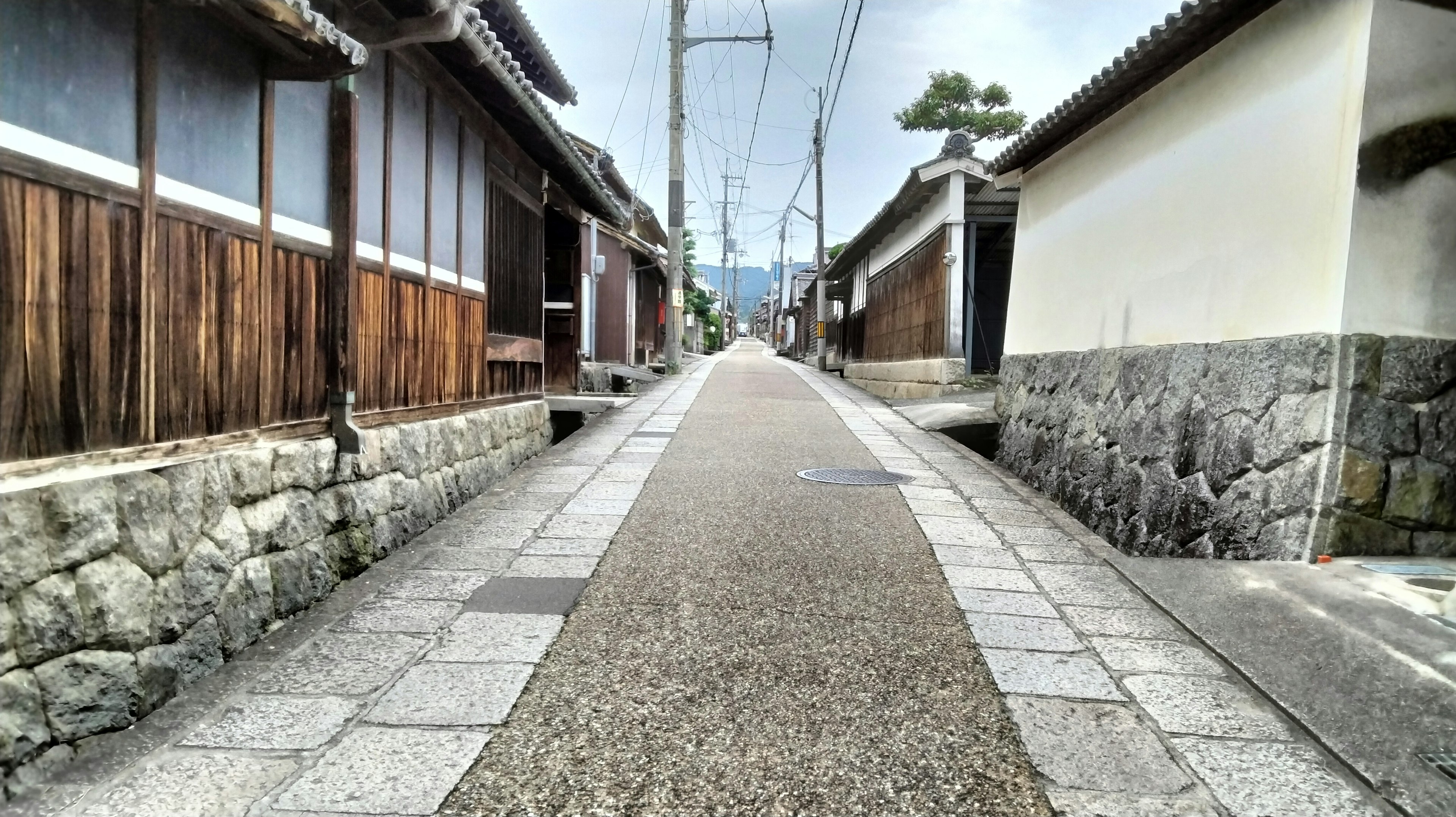 Camino estrecho pavimentado de piedras flanqueado por casas de madera tradicionales