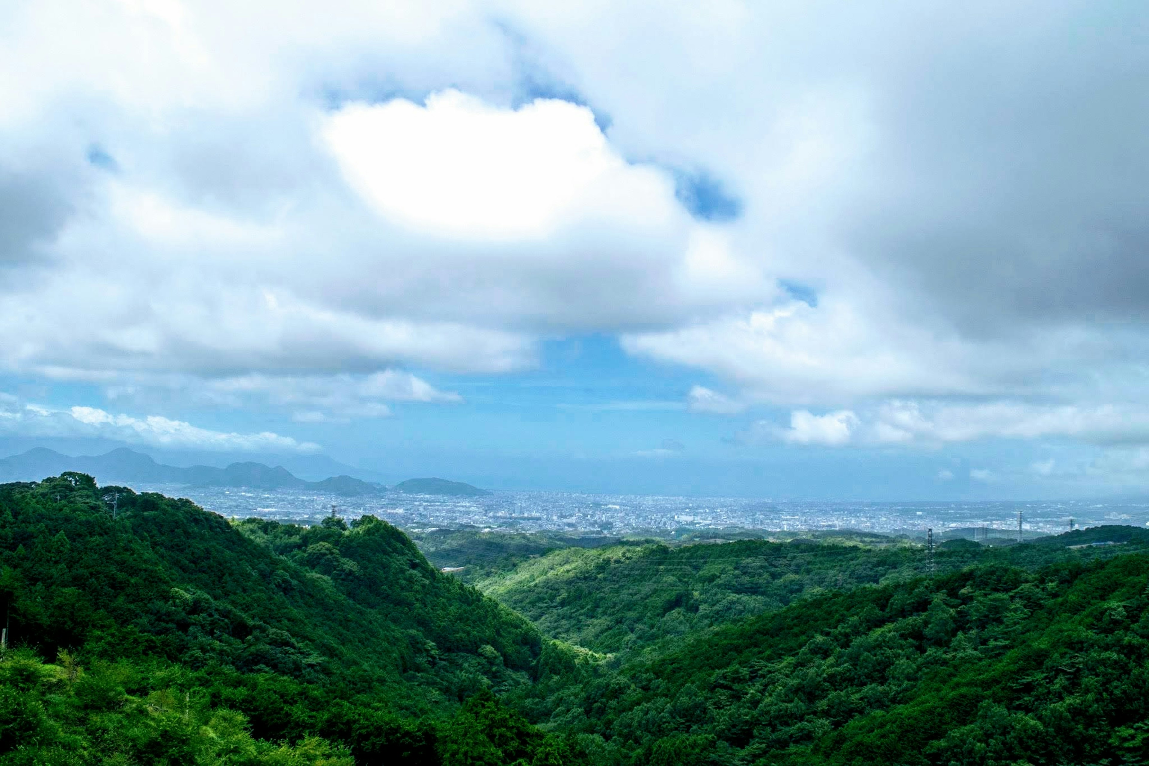 Üppiges grünes Tal mit blauem Himmel und Wolken