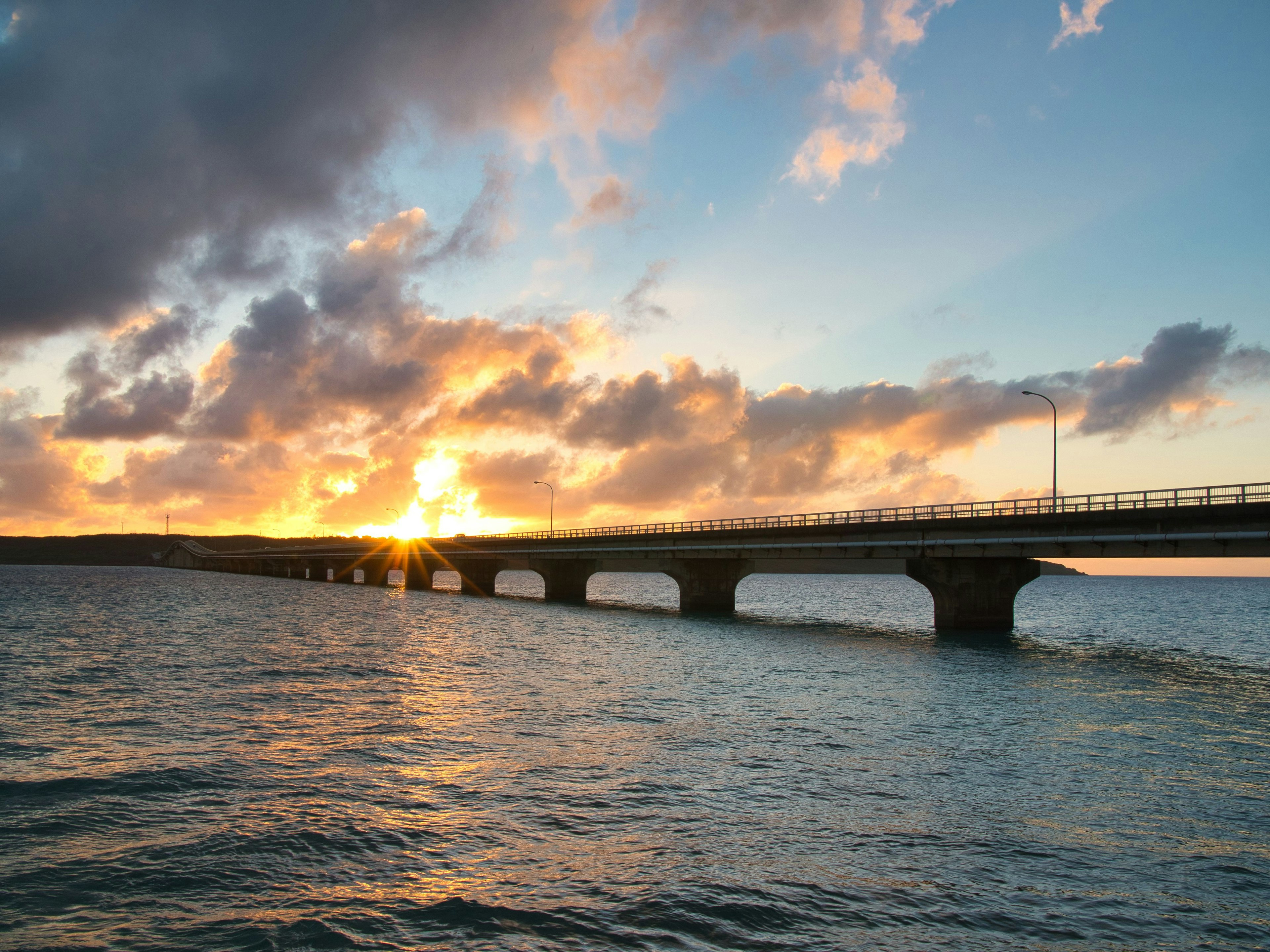 Sonnenuntergang über einer Brücke im Wasser