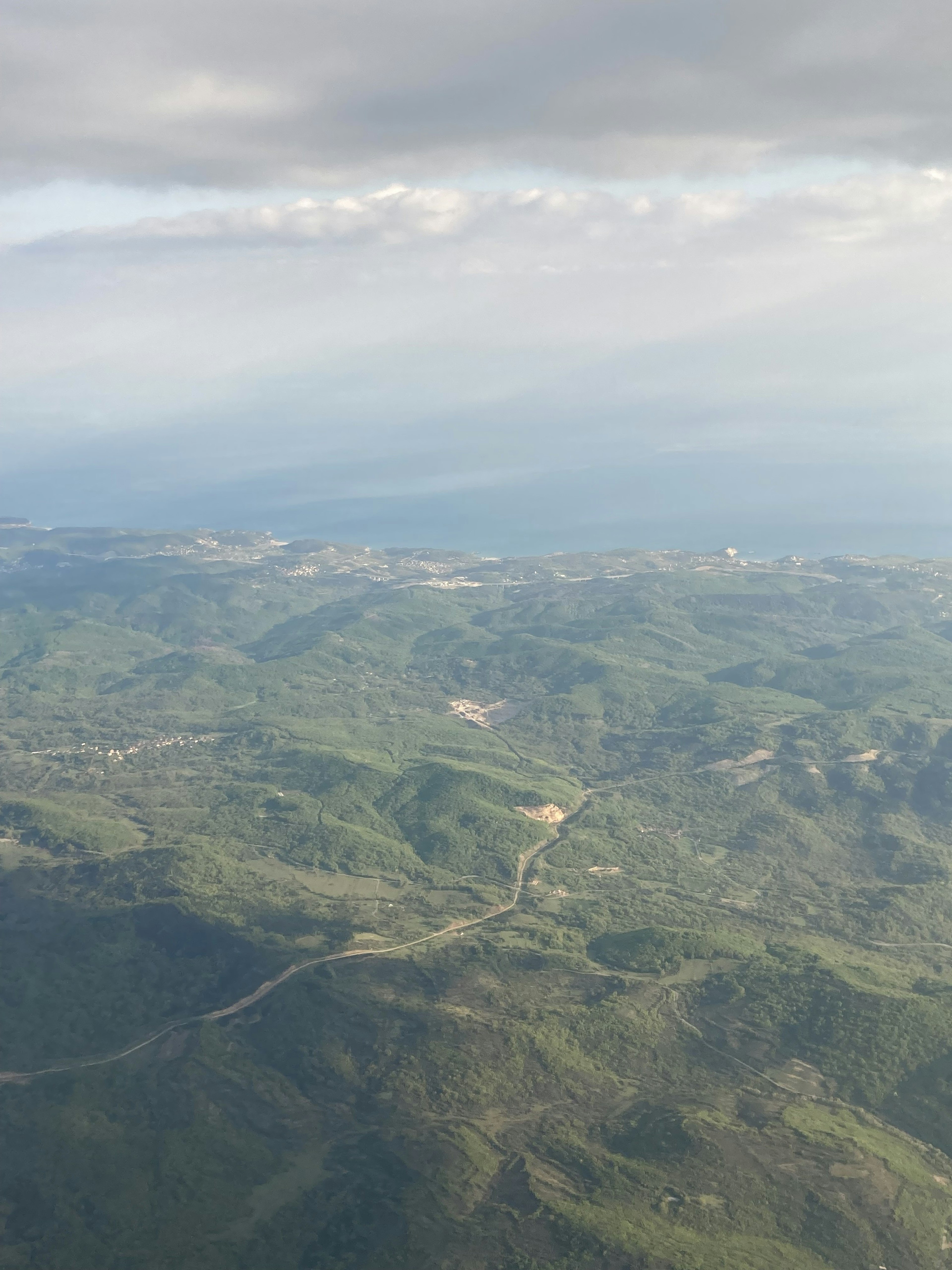 Aerial view of lush green hills and ocean