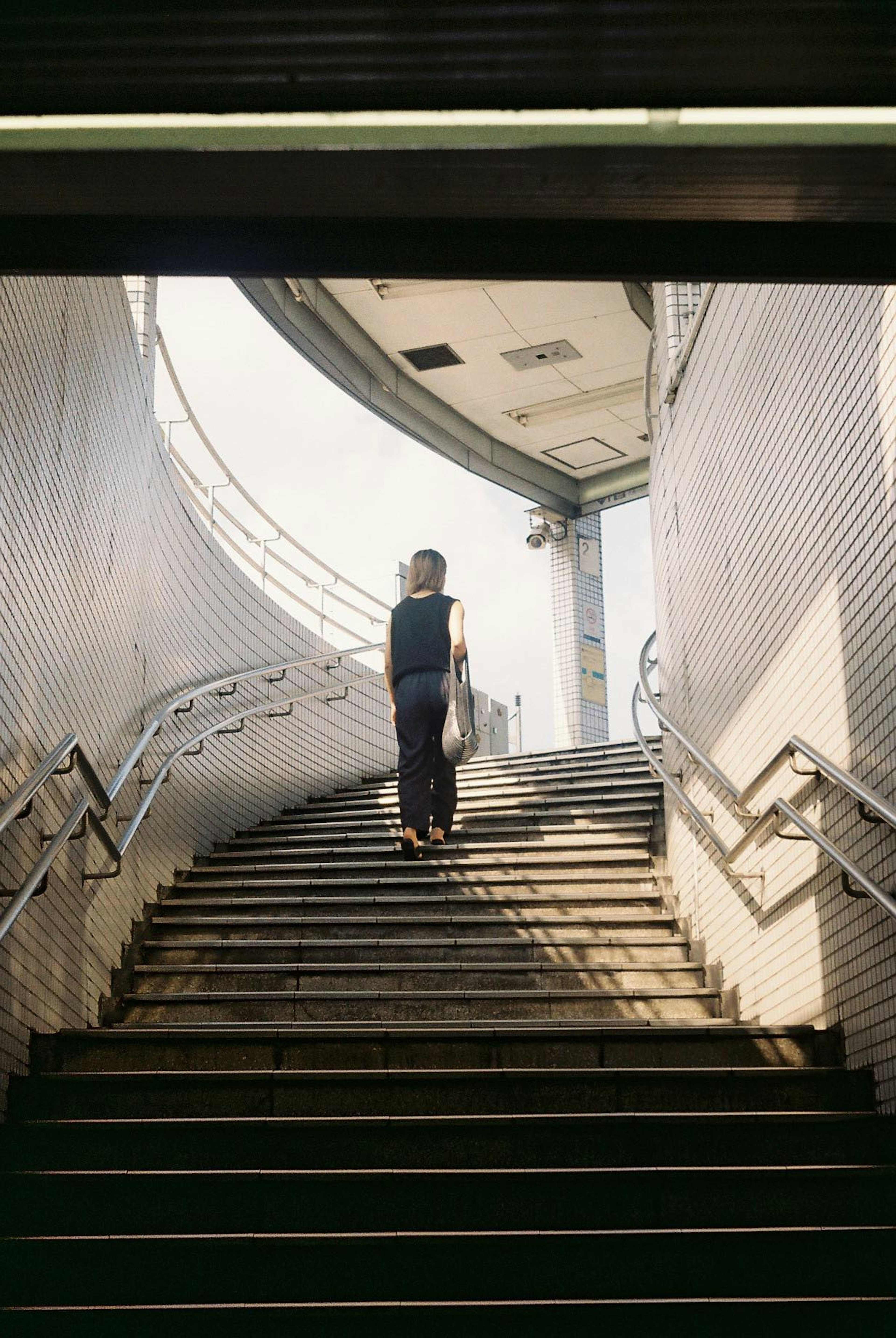 Persona subiendo escaleras en un espacio arquitectónico moderno