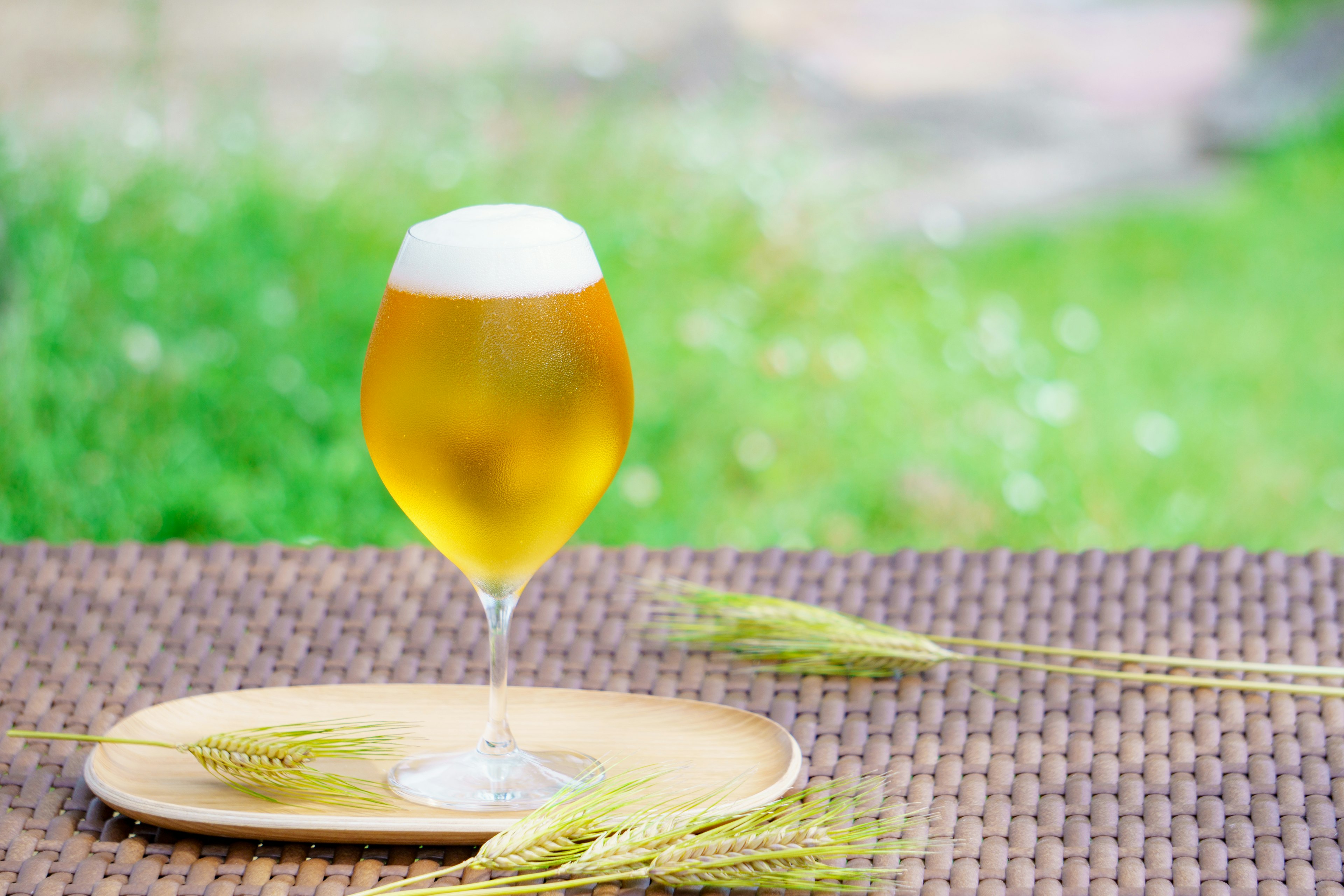 A glass of beer with foam and green background