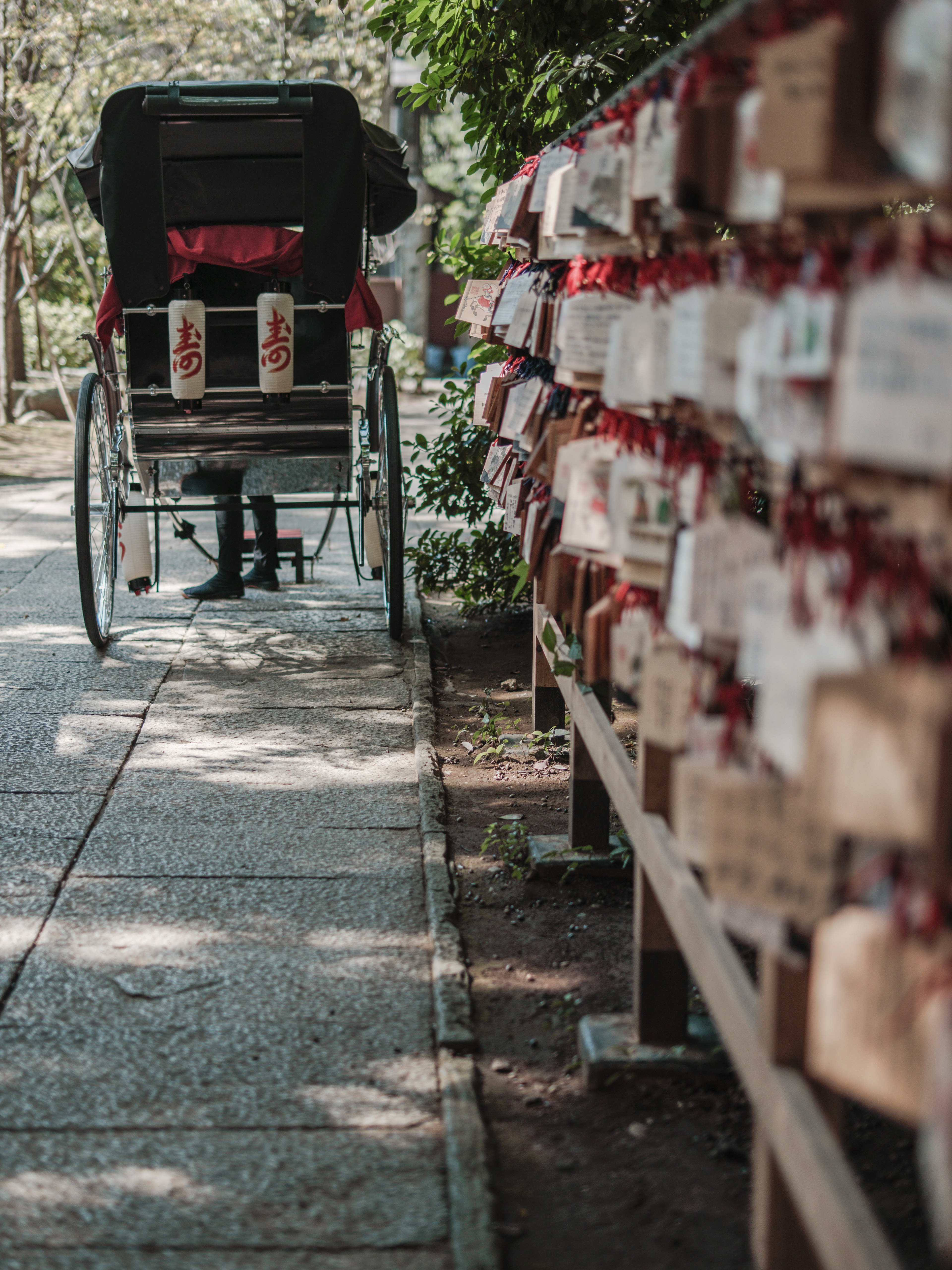 Rickshaw sur un chemin à côté de rangées de plaques de prière en bois