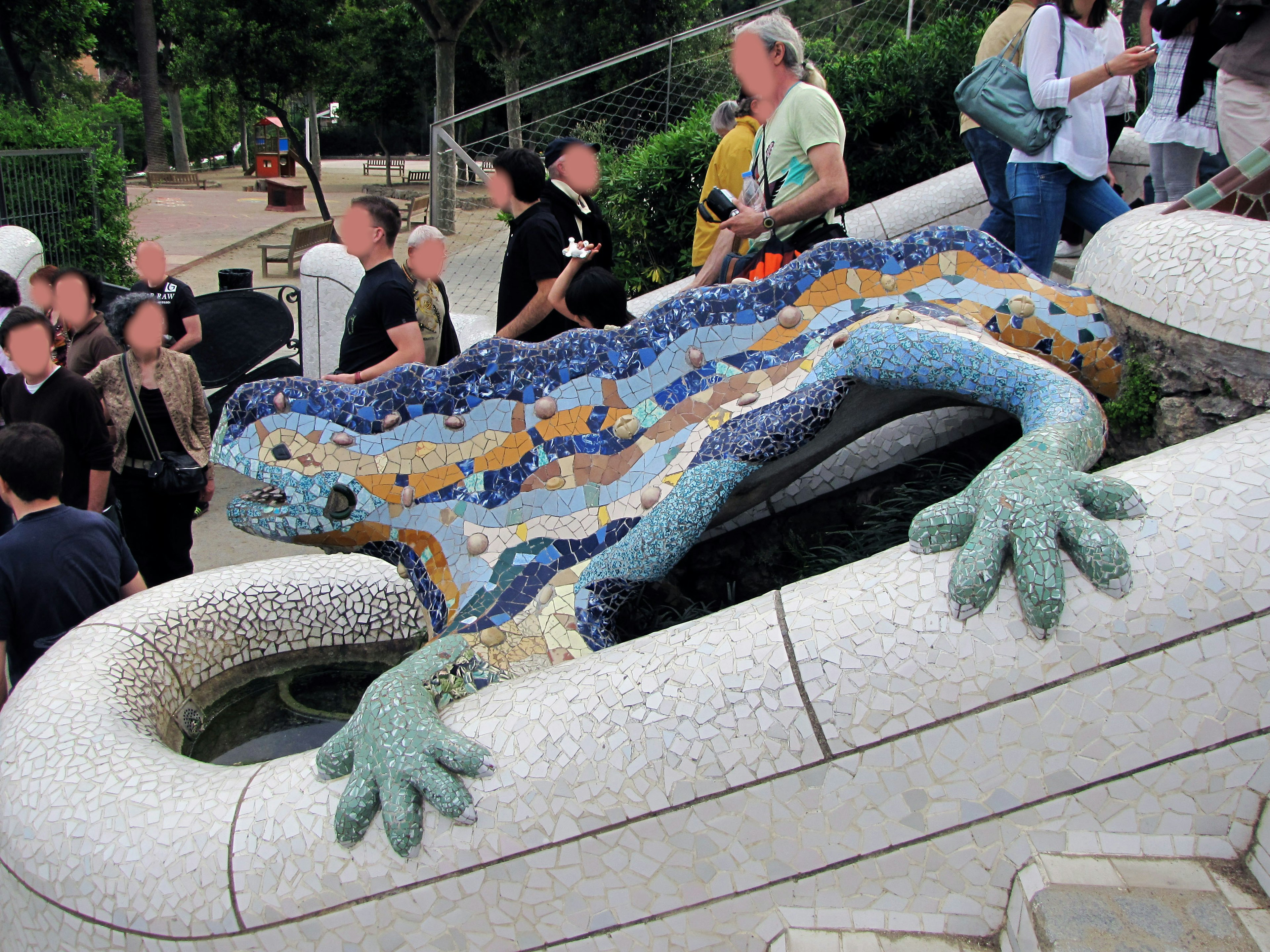 Colorful mosaic lizard sculpture at Park Güell in Barcelona with tourists