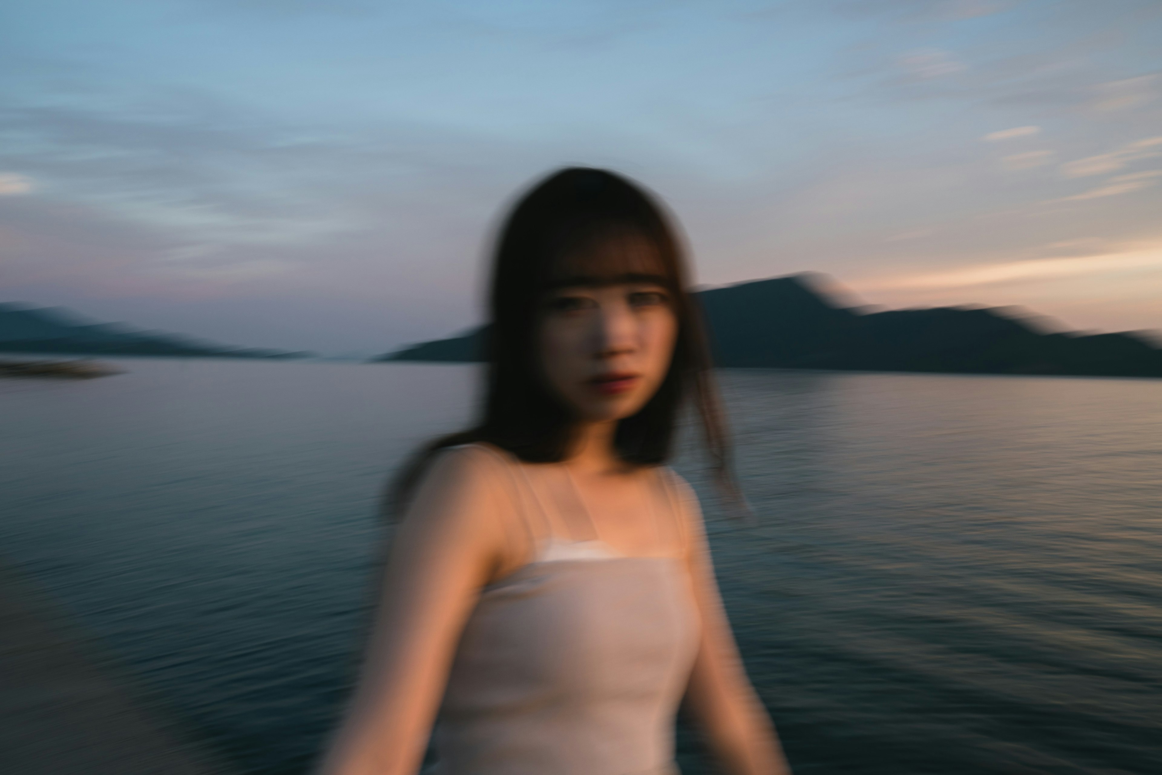 Portrait of a woman standing in front of a lake with a blurred background