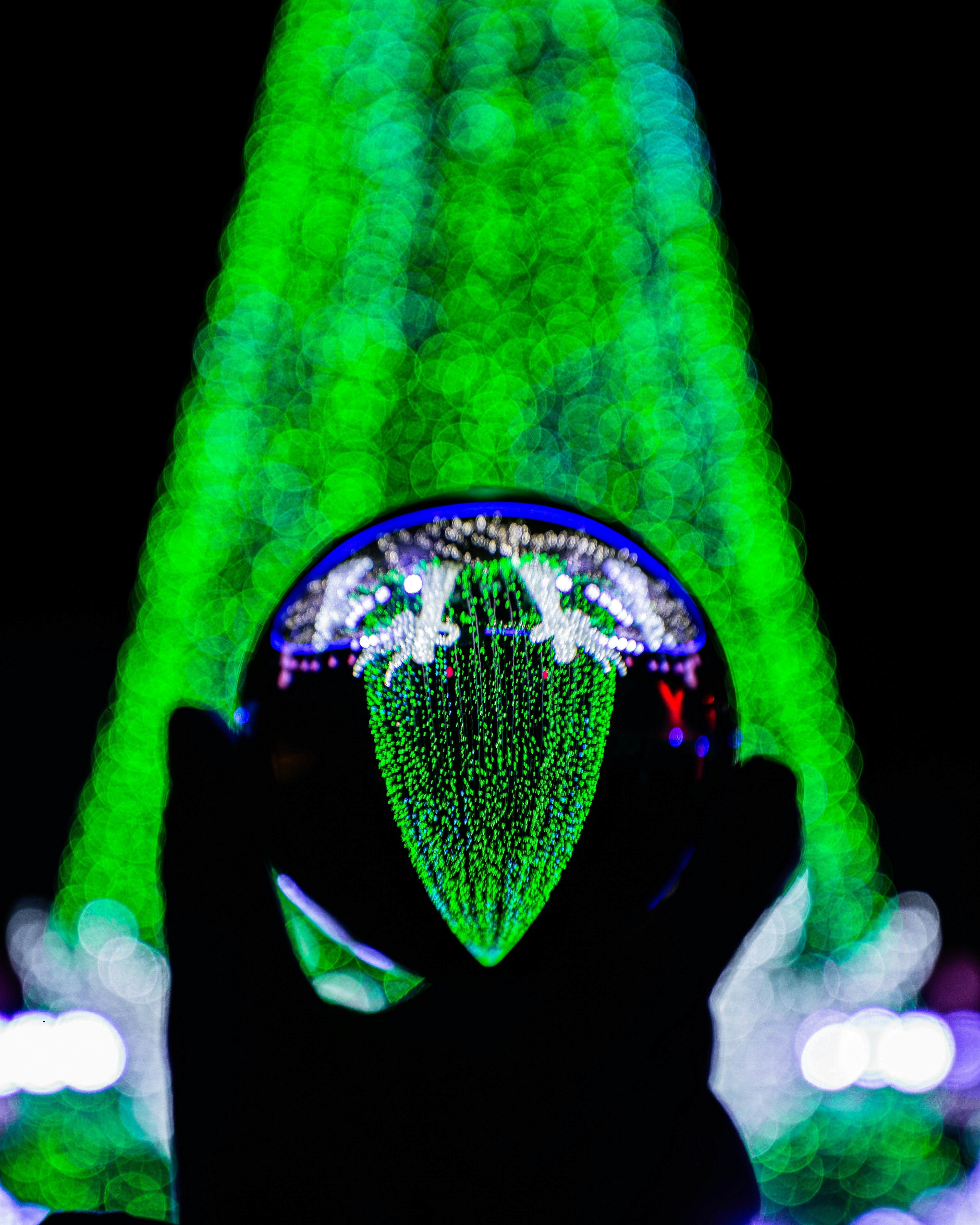 Une boule en cristal reflétant des faisceaux de lumière verte rayonnant vers l'extérieur