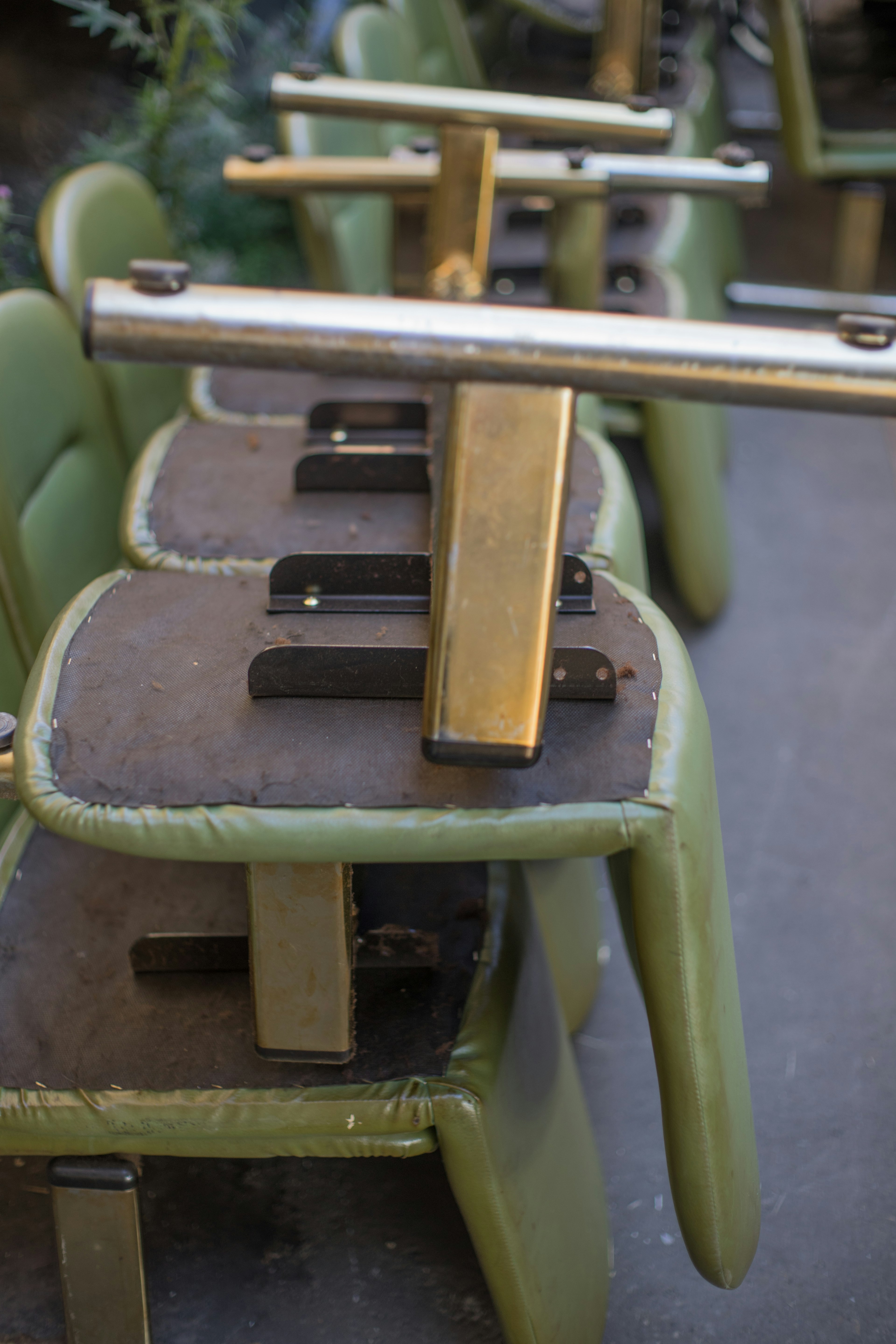 Stacked vintage green chairs with visible metal components