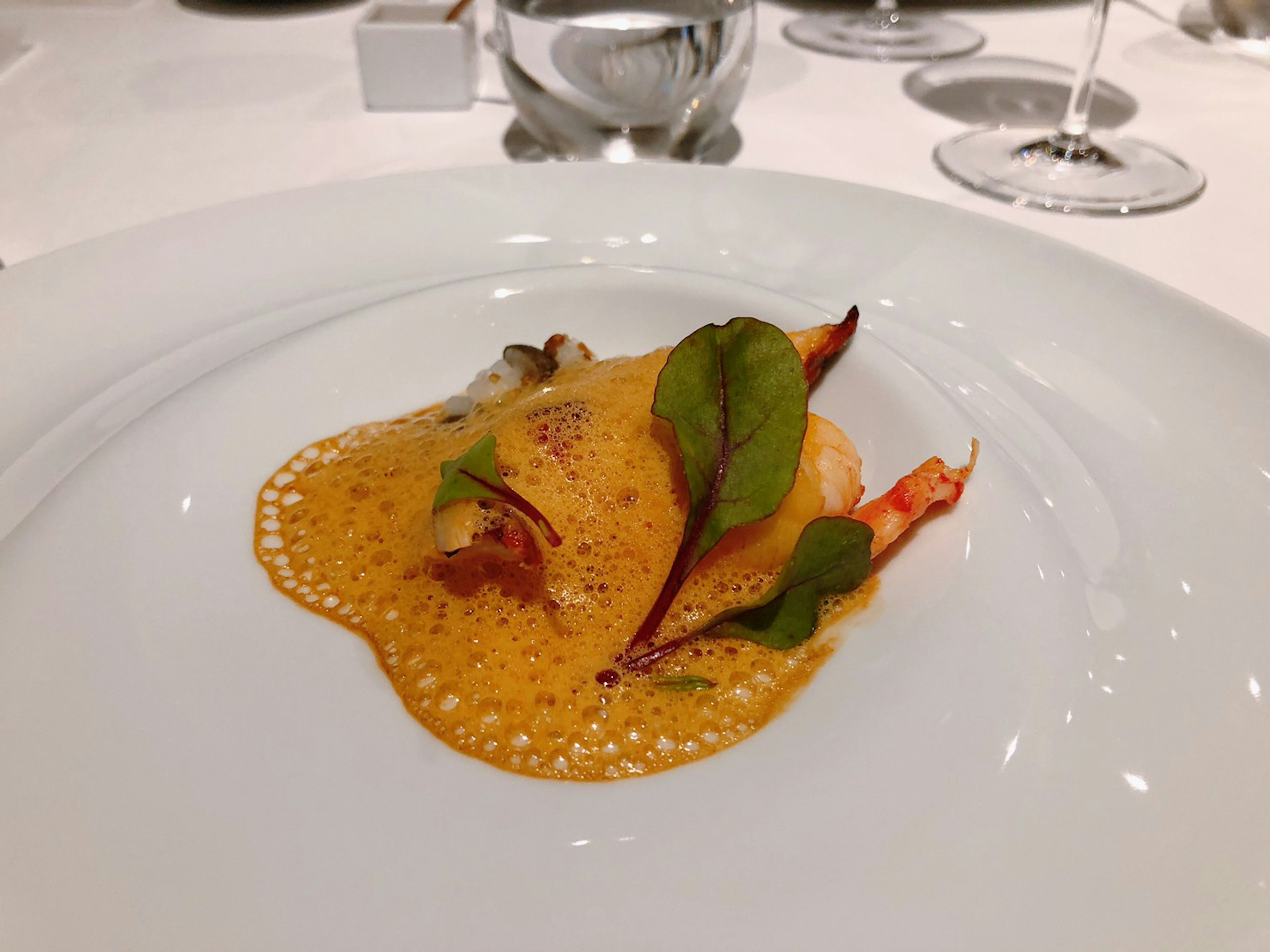 Plat élégant sur une assiette blanche avec des fruits de mer et des herbes fraîches