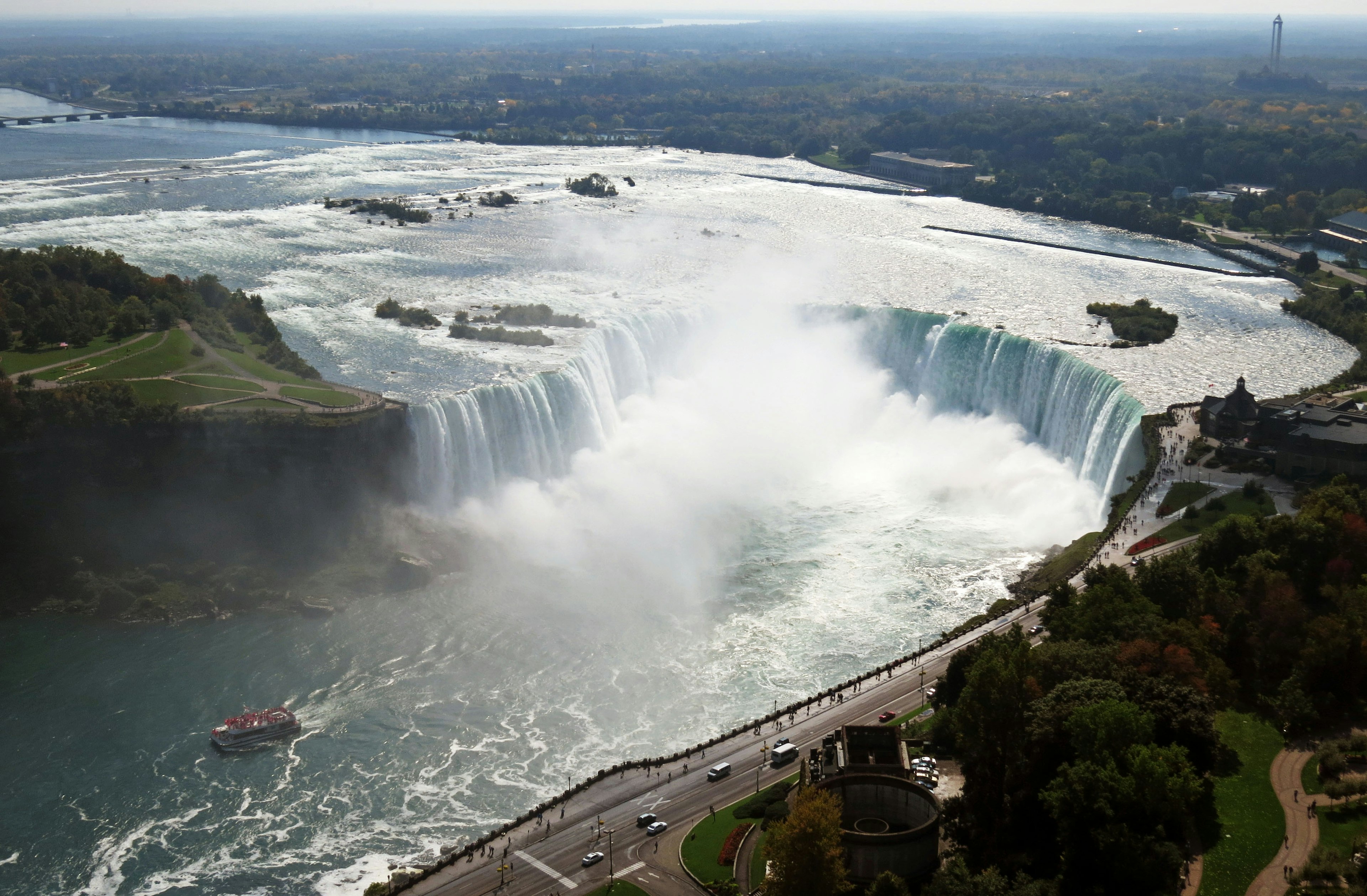 Luftaufnahme der Niagarafälle mit majestätischen Wasserfällen umgeben von üppigem Grün und Nebel