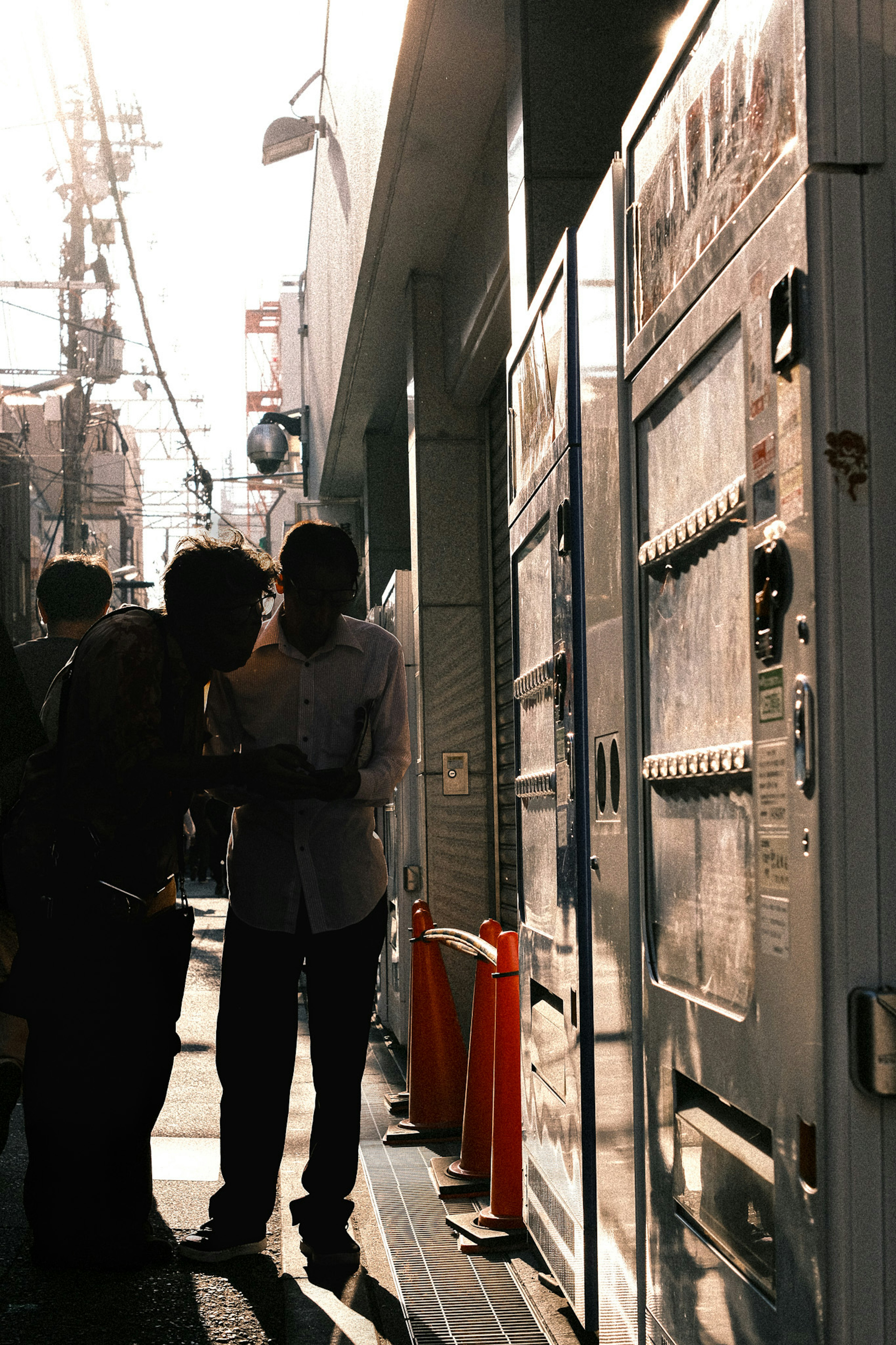 夕暮れ時の街角で人々が話し合うシルエット