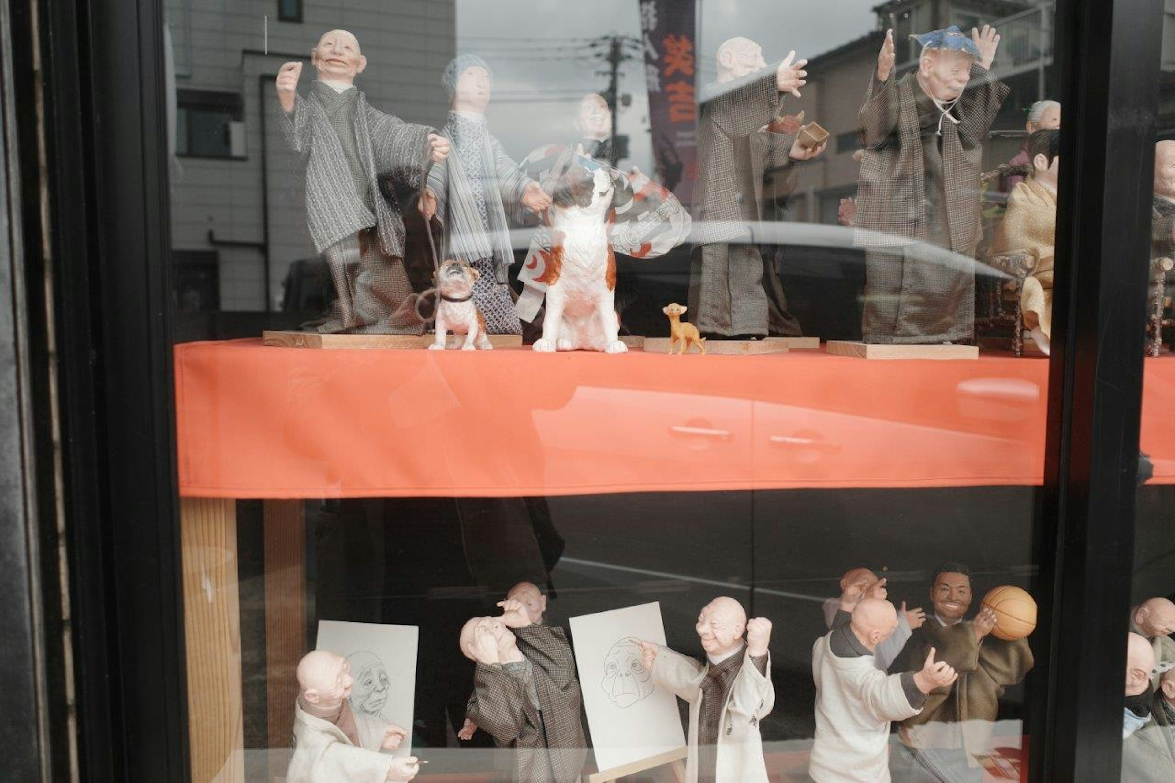 Tonfiguren in einem Schaufenster, die verschiedene Posen zeigen