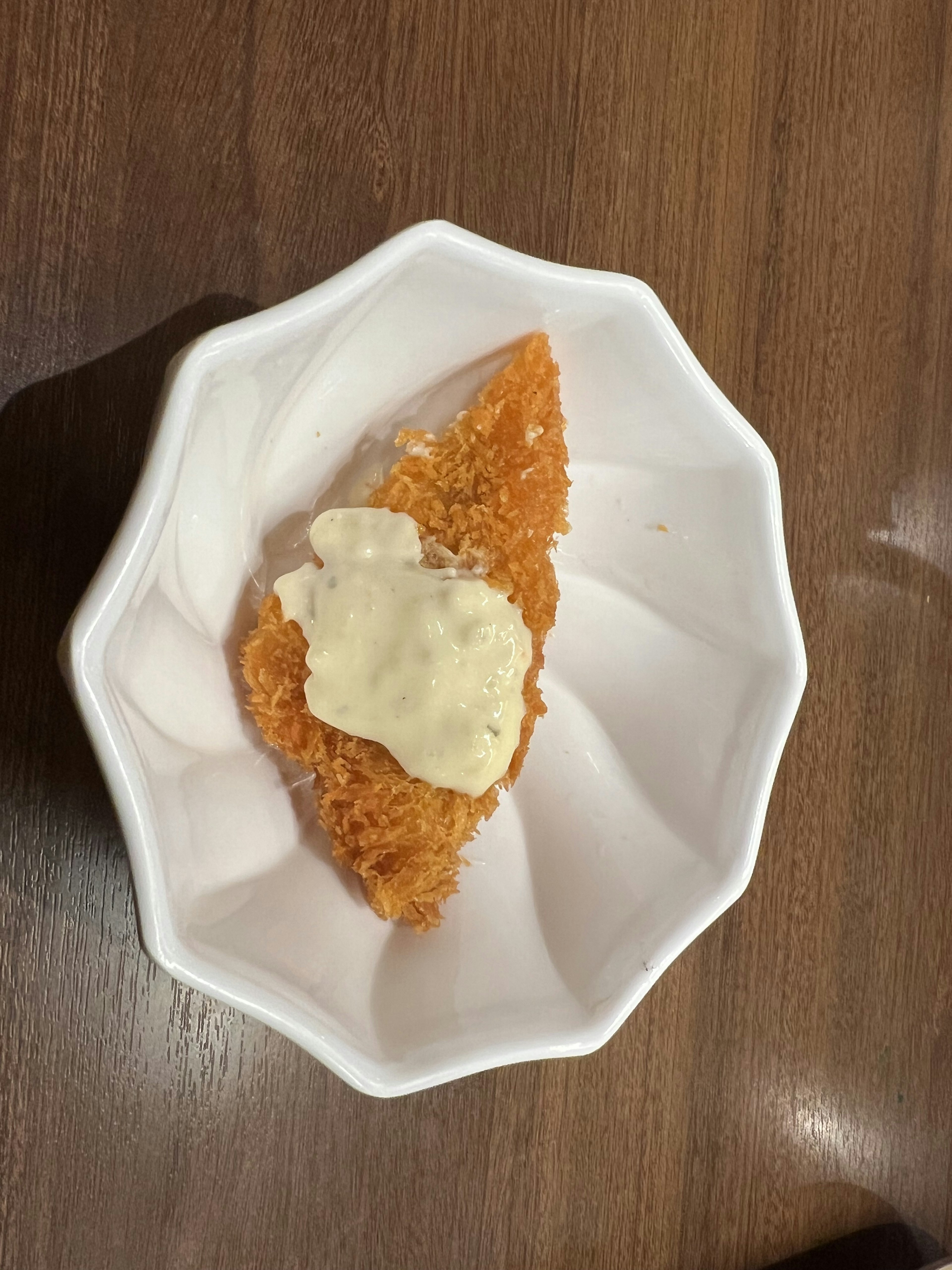 Crispy fried fish with mayonnaise sauce on a white dish