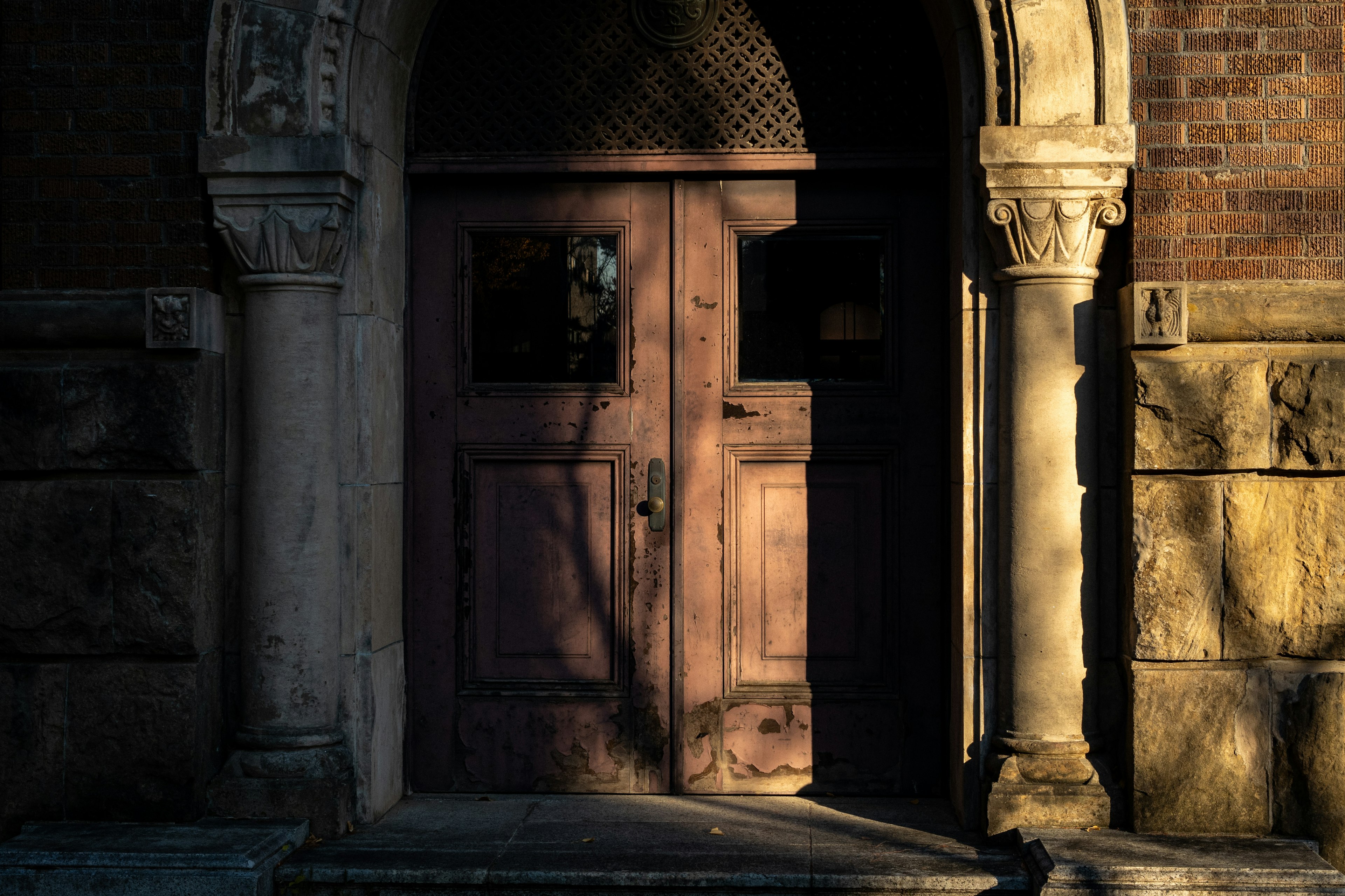 Entrance featuring an old wooden door and stone arch structure