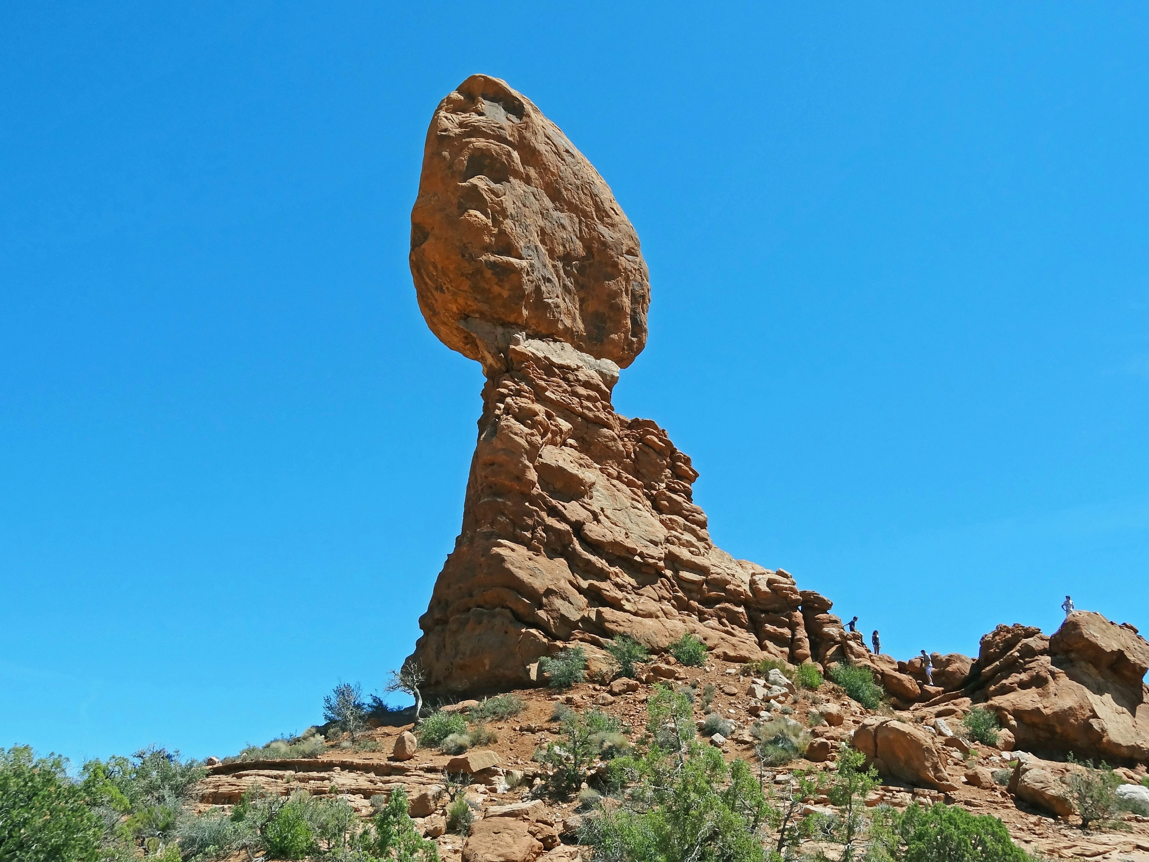 A weathered rock formation standing tall against a blue sky