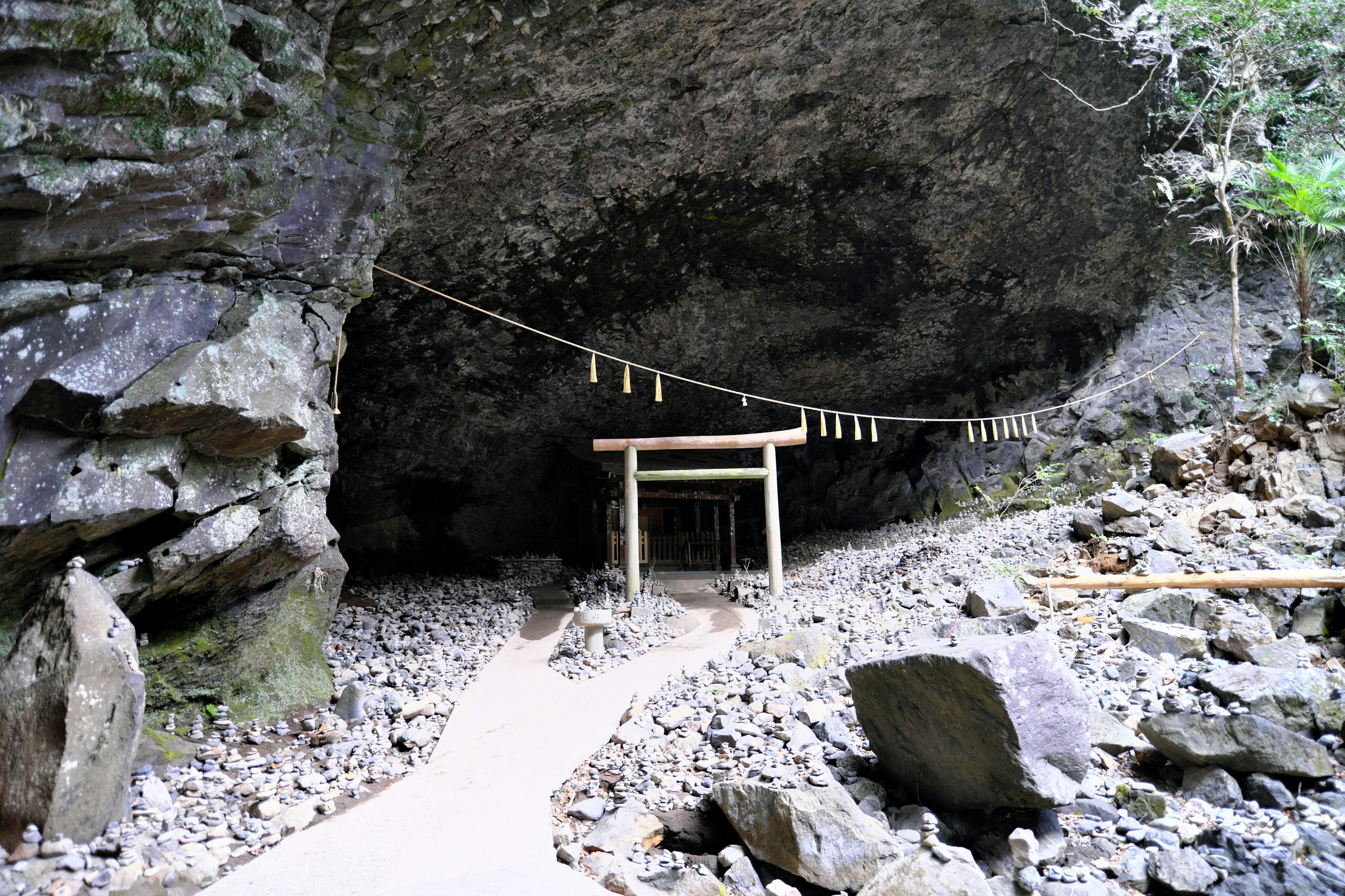 Wooden platform with decorative rope at the entrance of a rocky cave