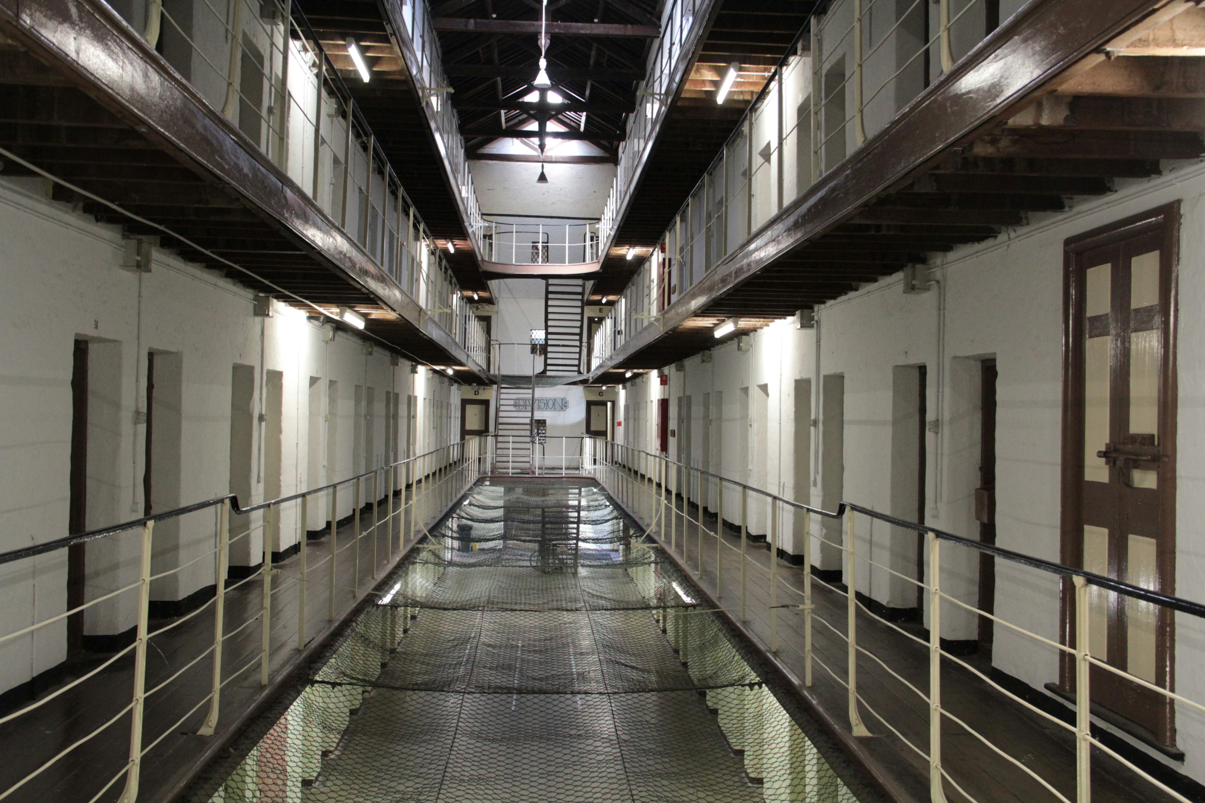 Interior of a prison featuring a long corridor with two floors