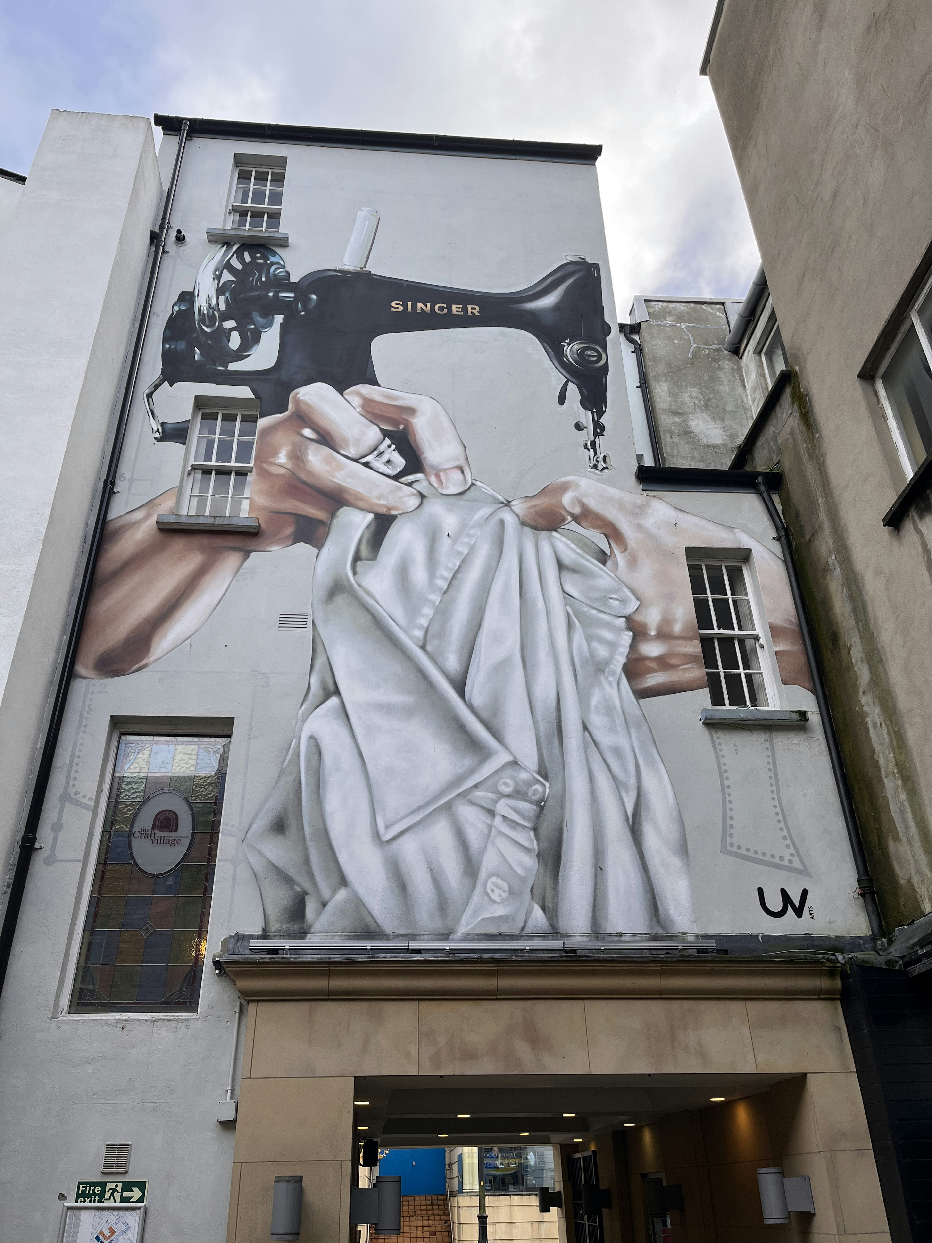 A large mural depicting a sewing machine and hands holding fabric