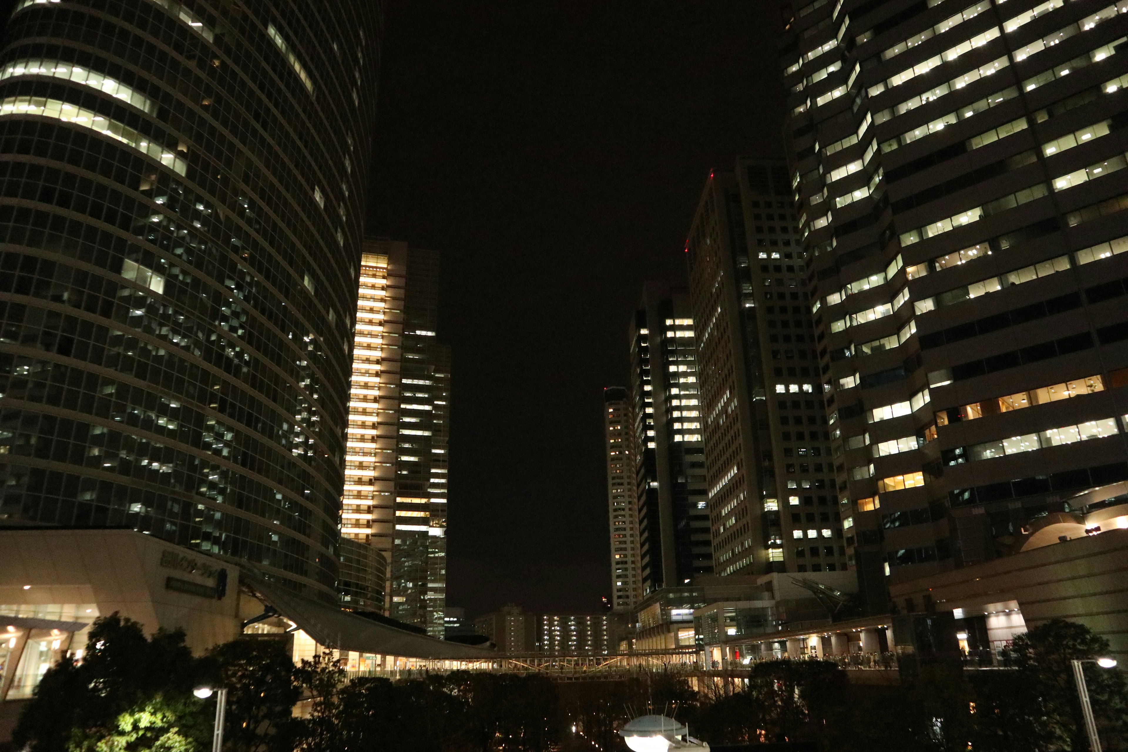 Night cityscape featuring tall buildings and illuminated windows