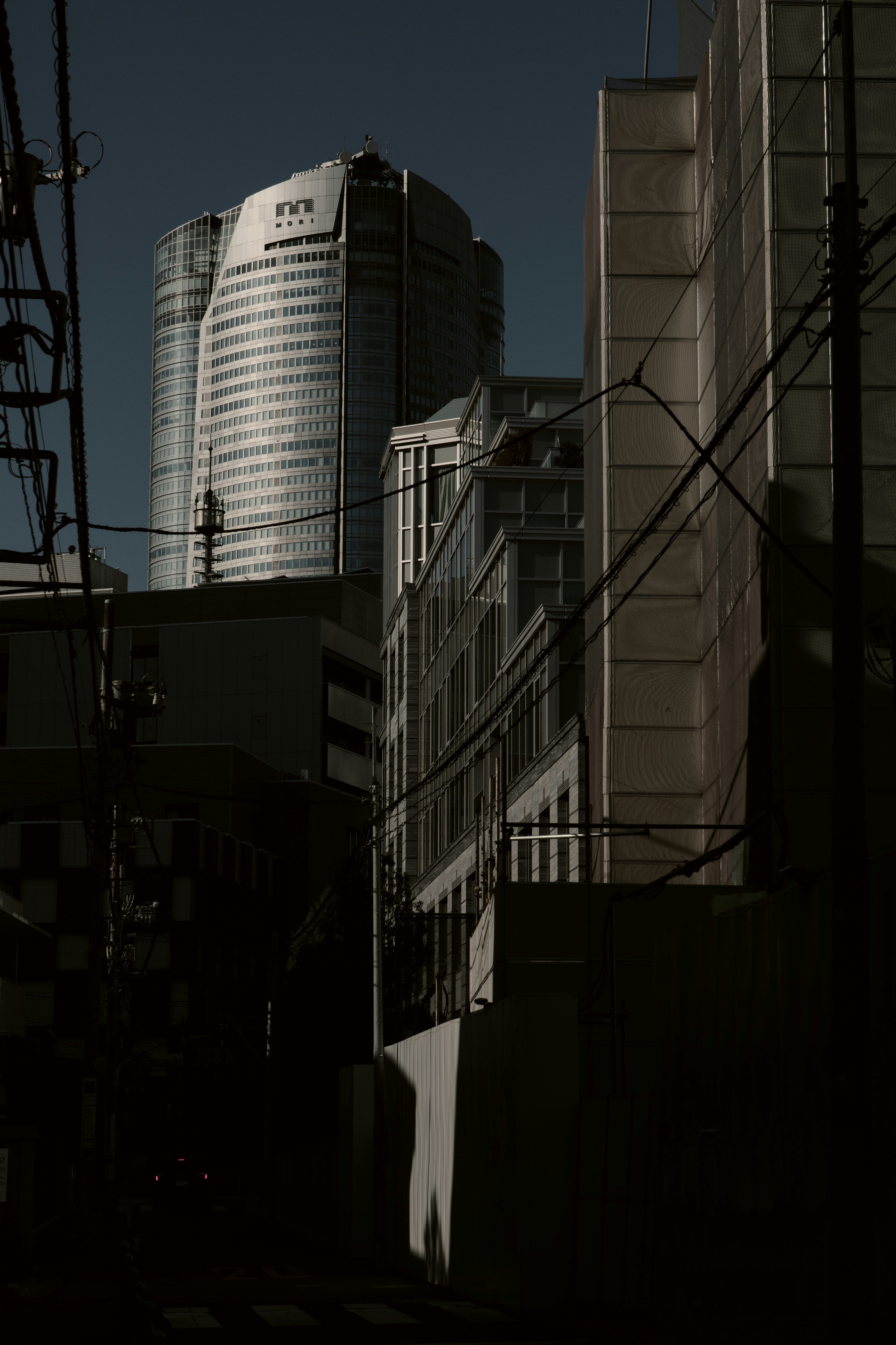 Silhouette eines Wolkenkratzers hinter städtischen Gebäuden in Tokio