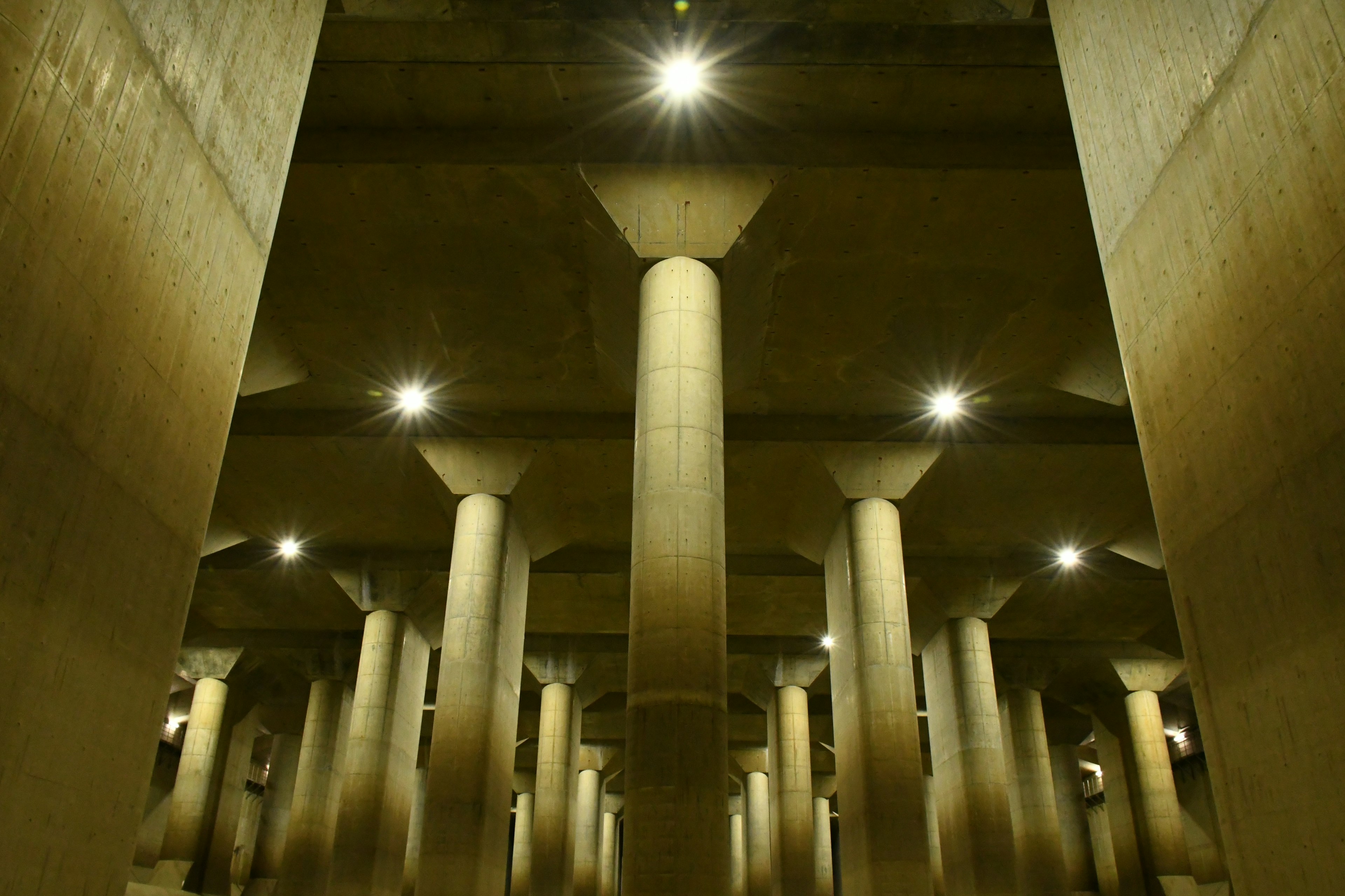 Espacio subterráneo con filas de columnas de concreto y luz