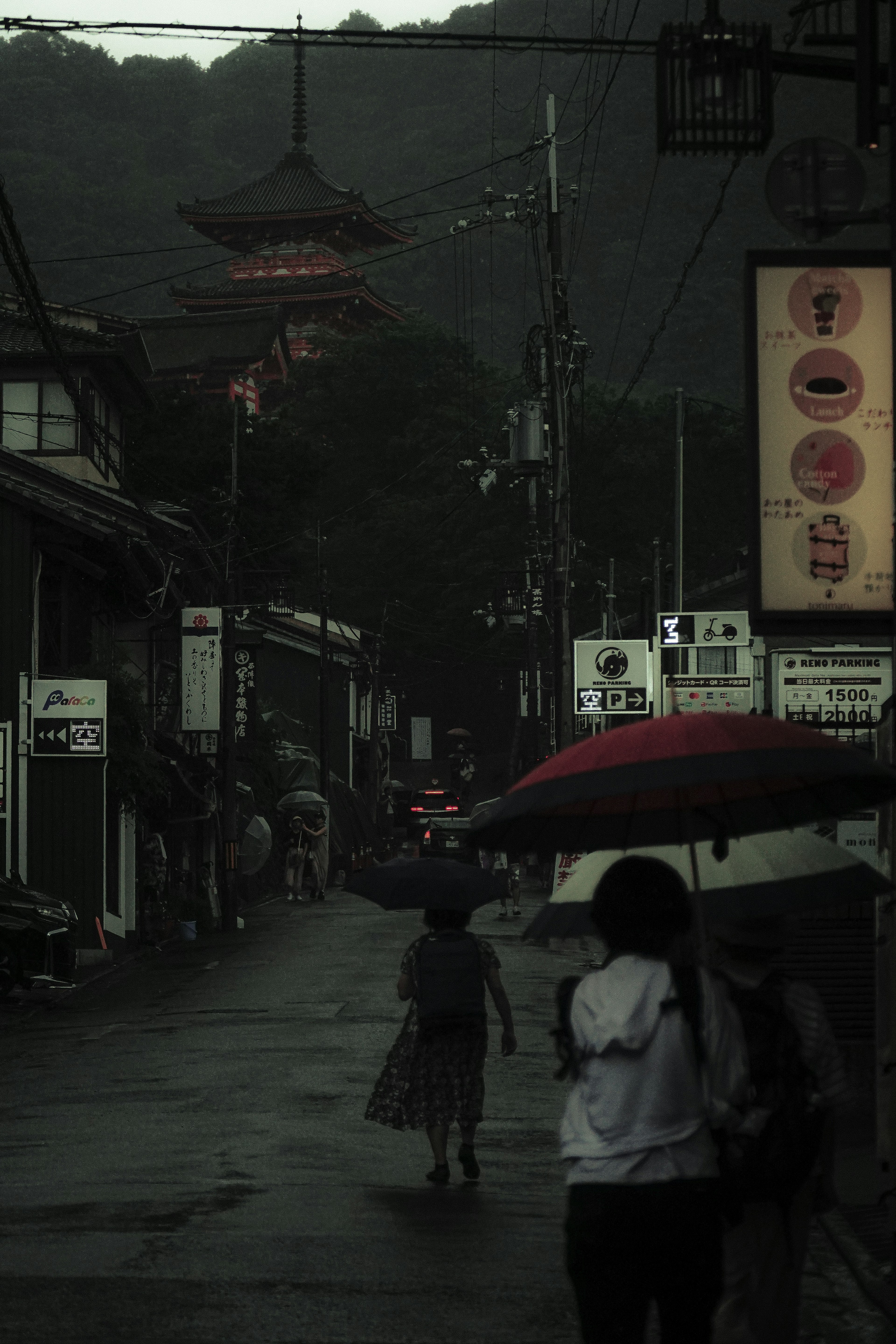 Quiet street scene in the rain with people holding umbrellas