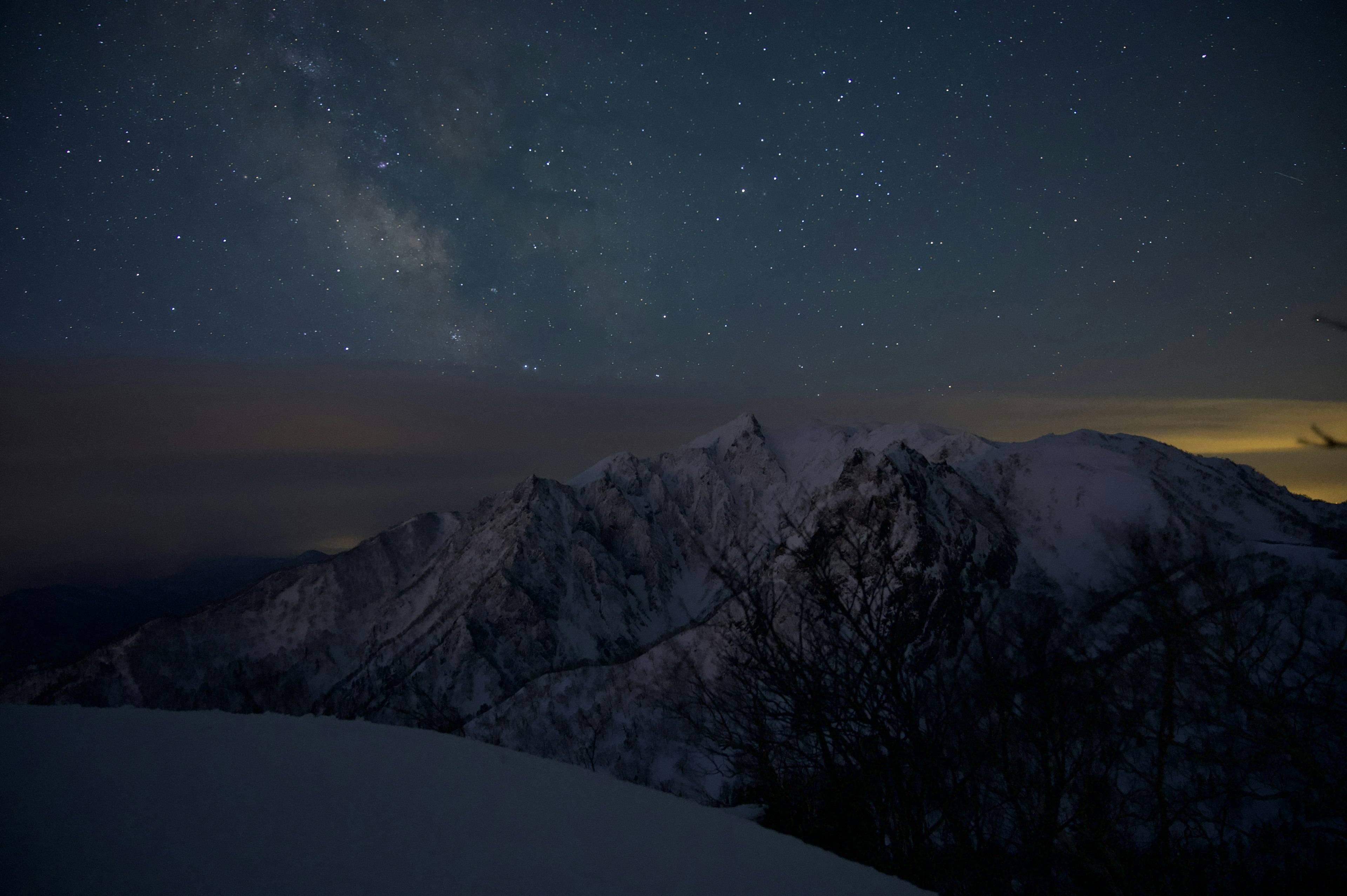 Nächtliche Aussicht auf schneebedeckte Berge unter einem sternenklaren Himmel