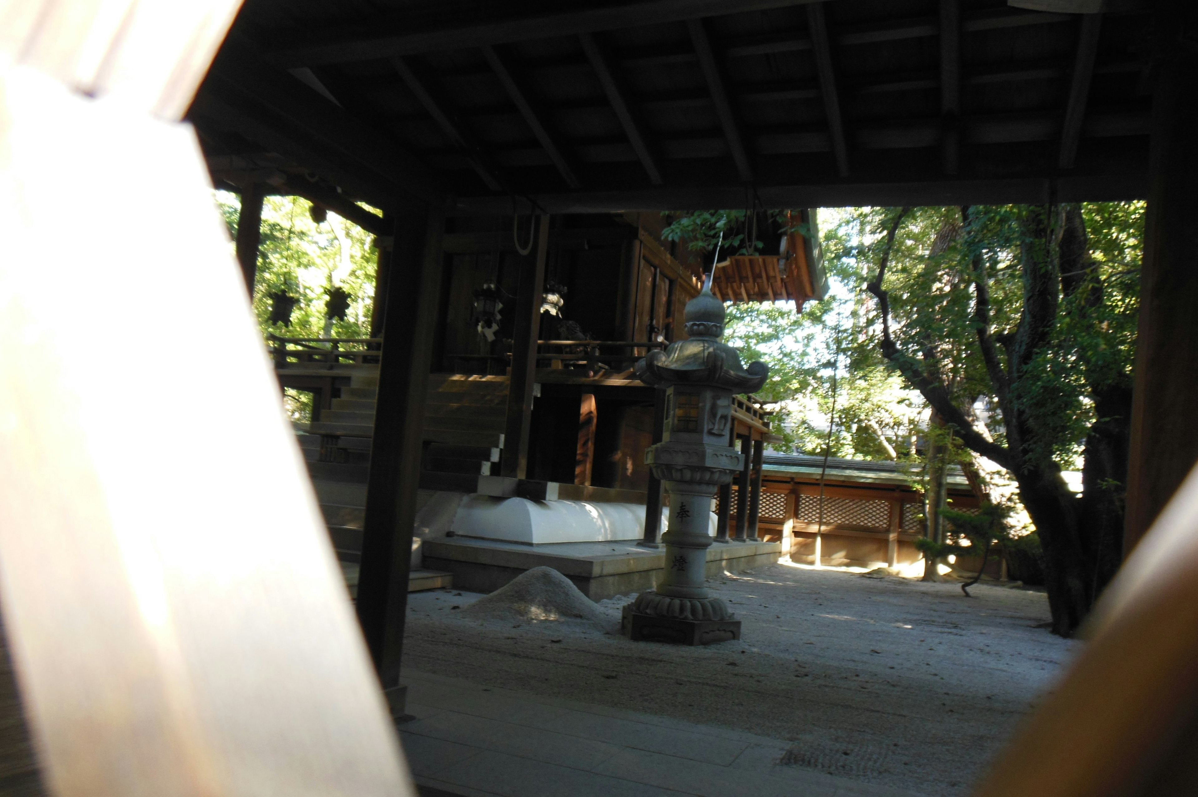 Interior of an old Japanese shrine with wooden pillars and a view of the garden