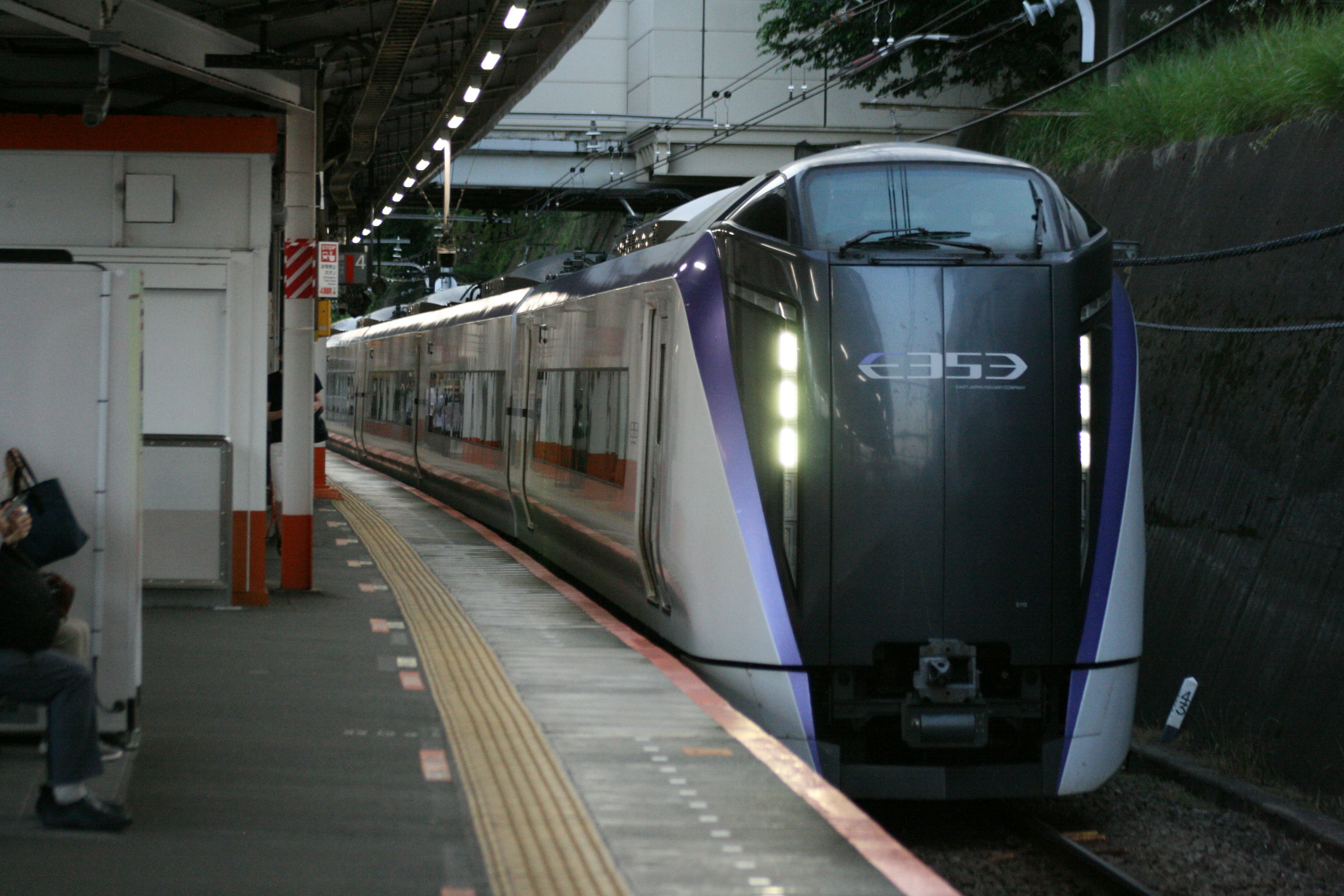 Tren futurista con acentos morados llegando a una estación