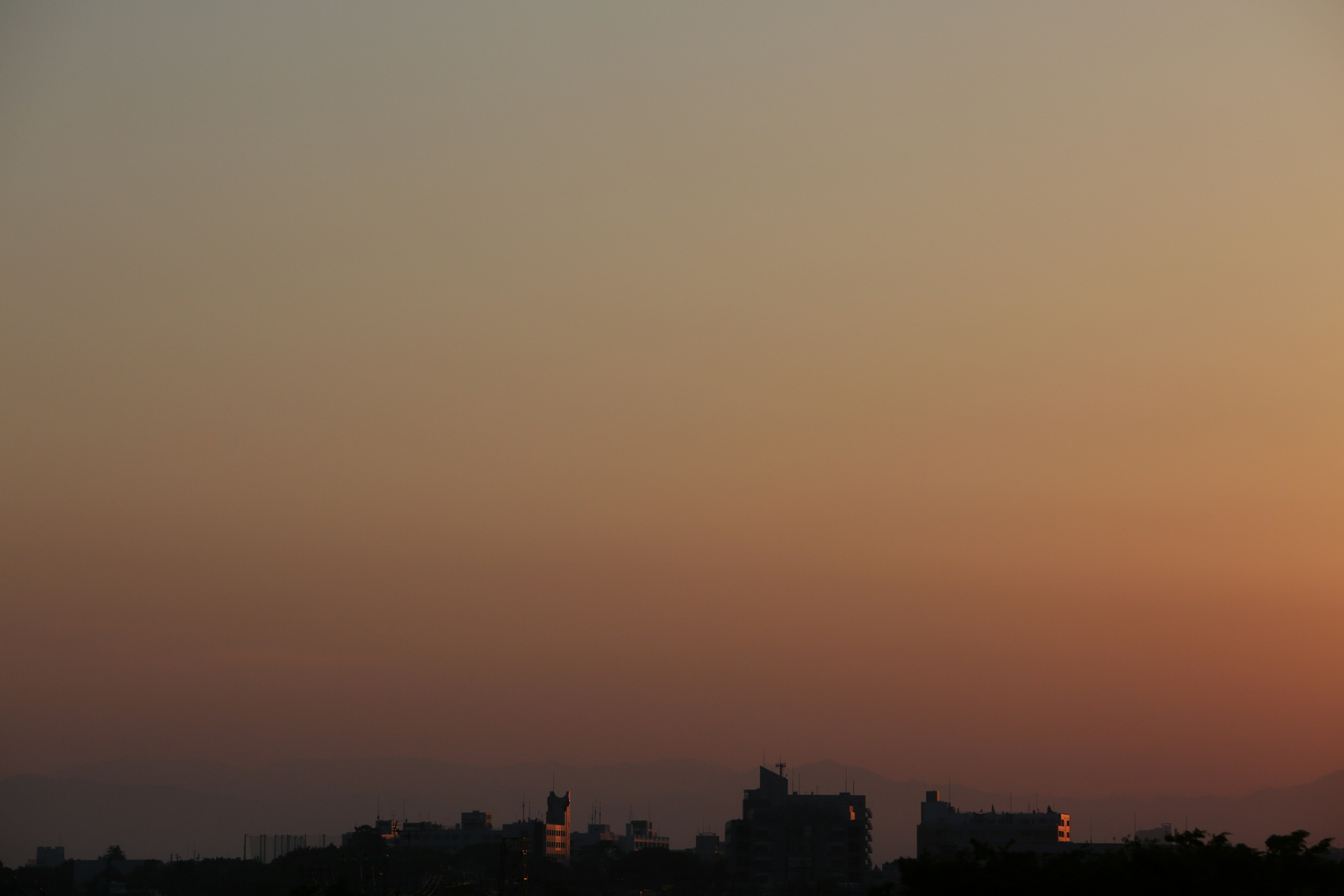 夕焼けの空とシルエットの建物が見える風景