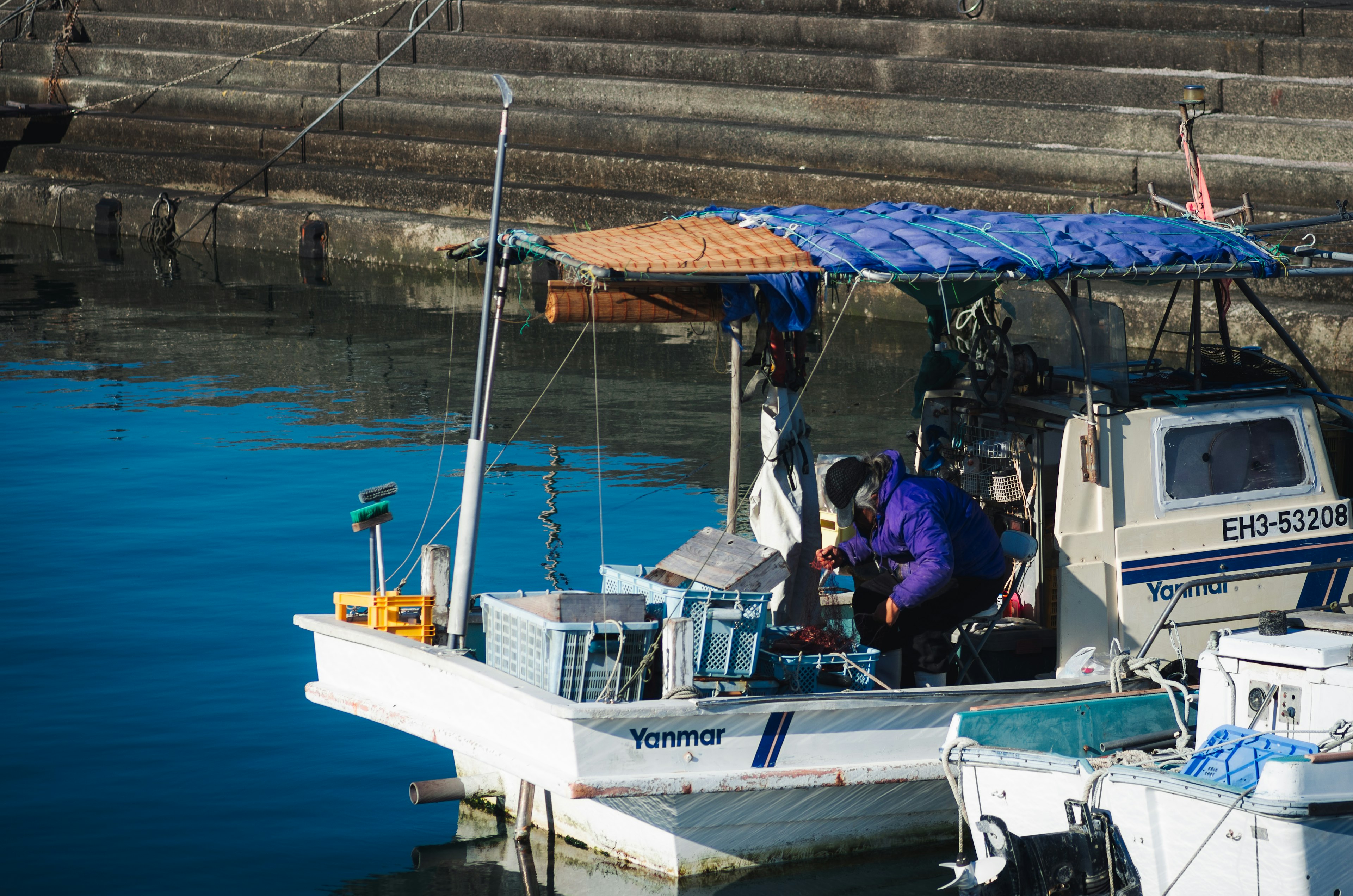 Homme travaillant sur un bateau de pêche avec un fond marin bleu