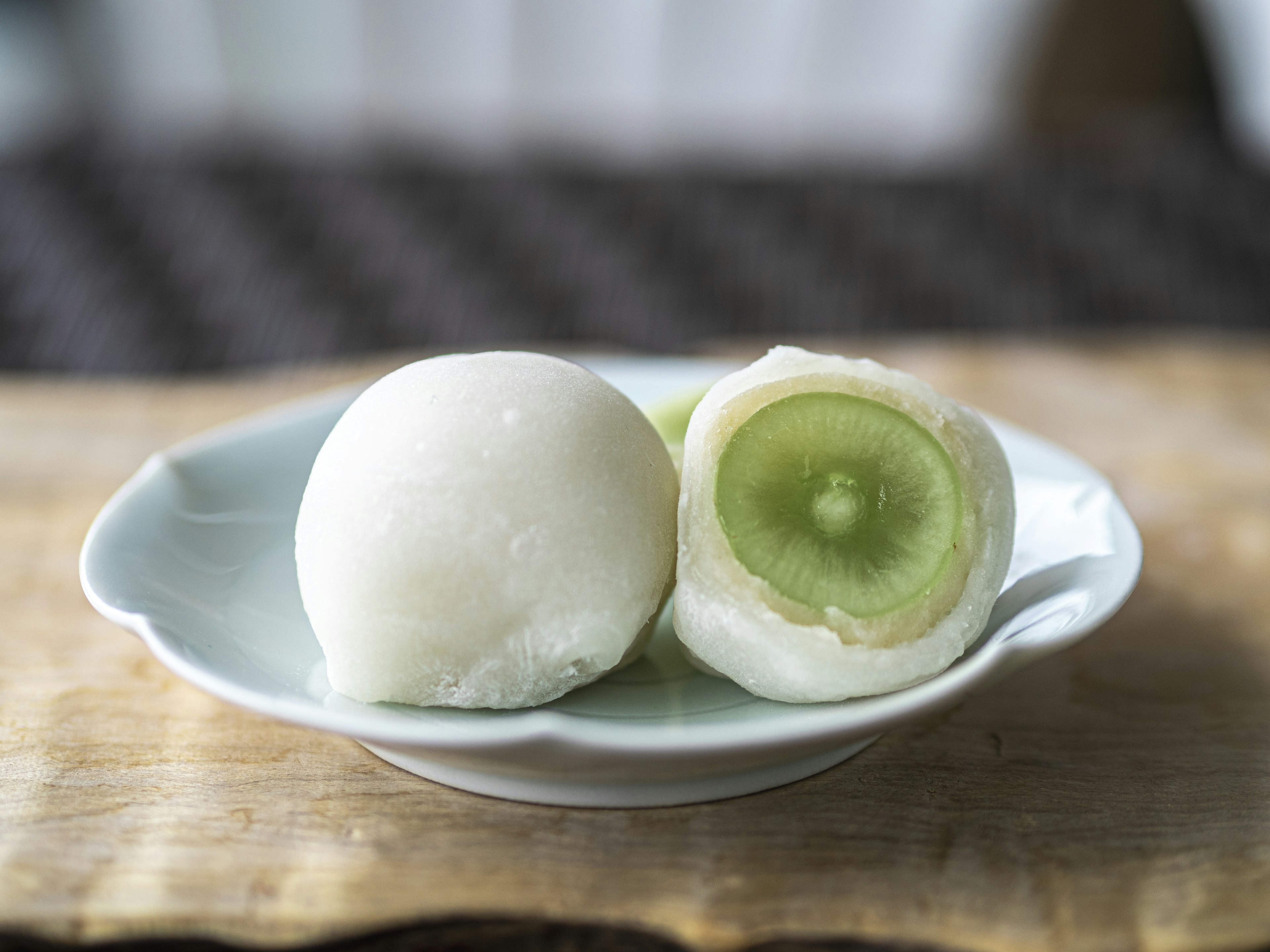 Mochi putih dengan isian hijau di piring