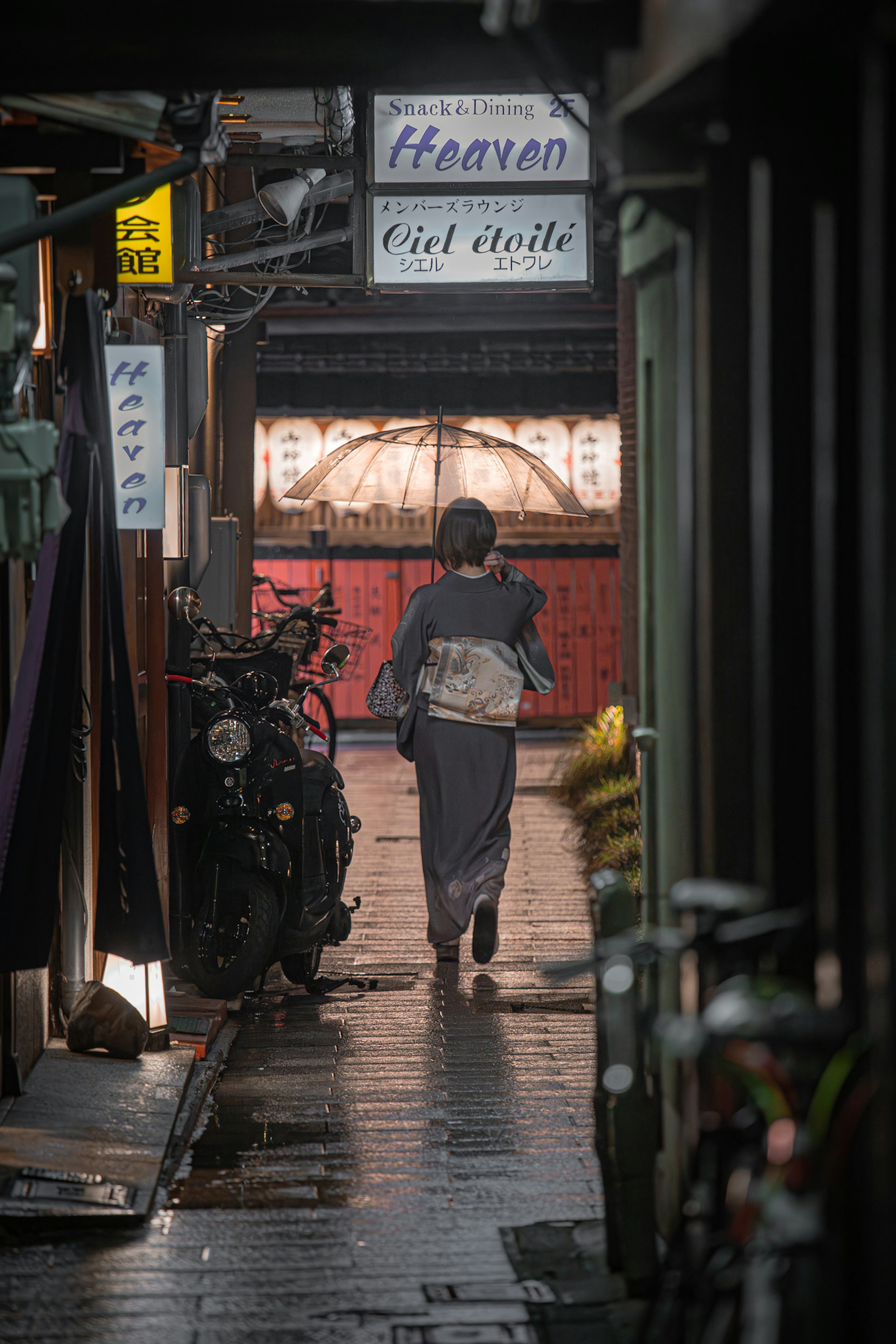 狭い路地を歩く人と看板のある街の風景