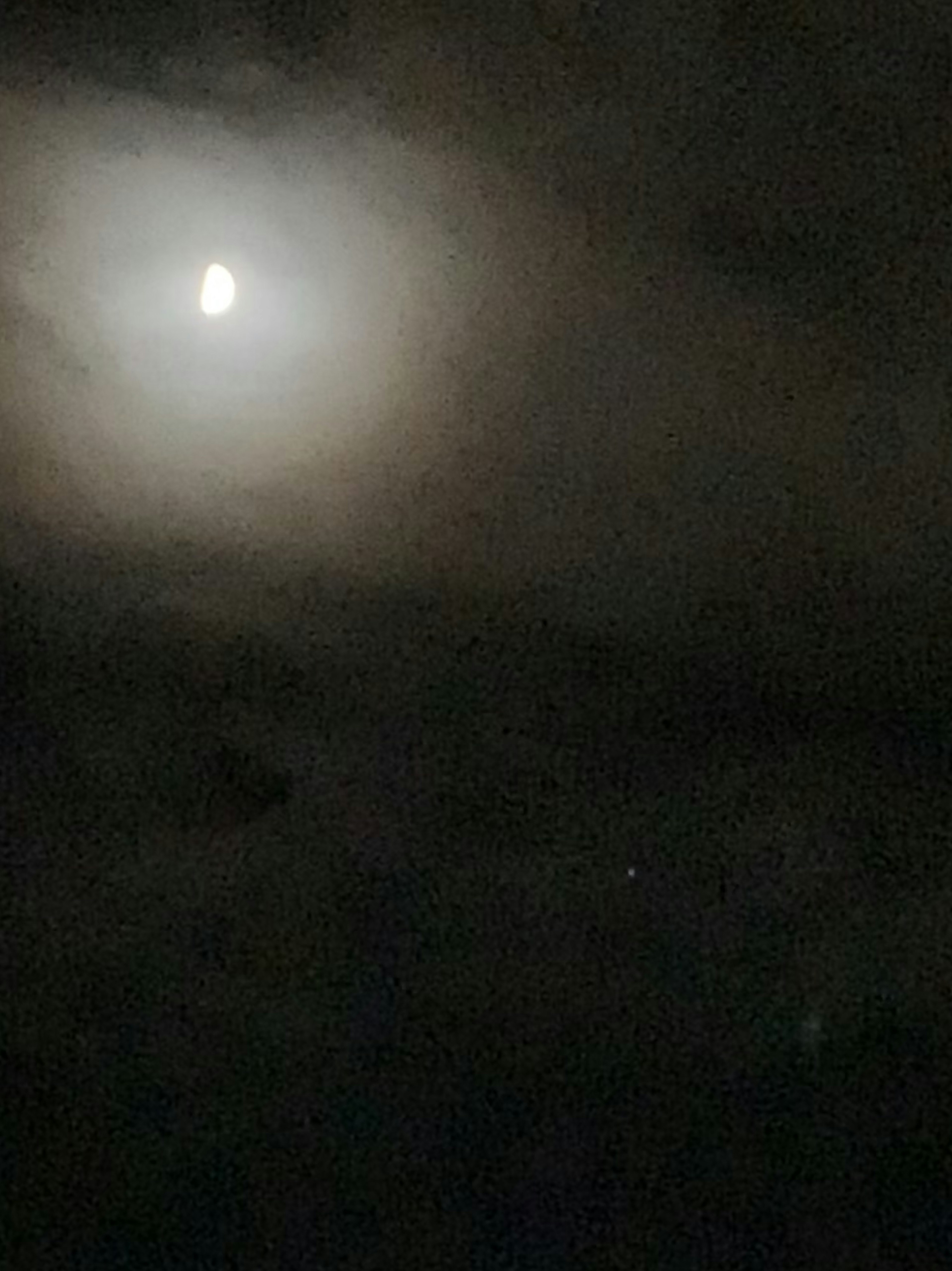 Cahaya bulan cerah dikelilingi awan gelap