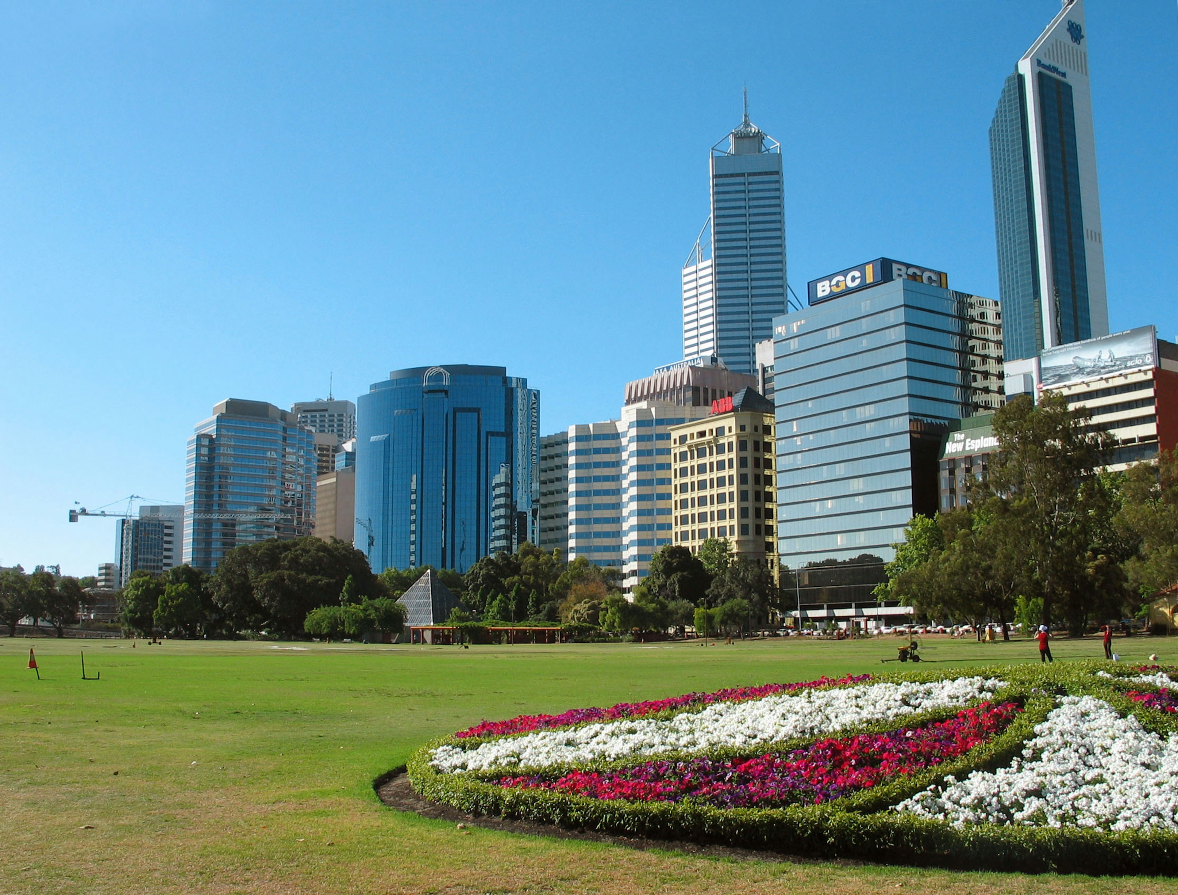 Stadtbild von Perth mit Wolkenkratzern und einer bunten Blumenanordnung in einem Park