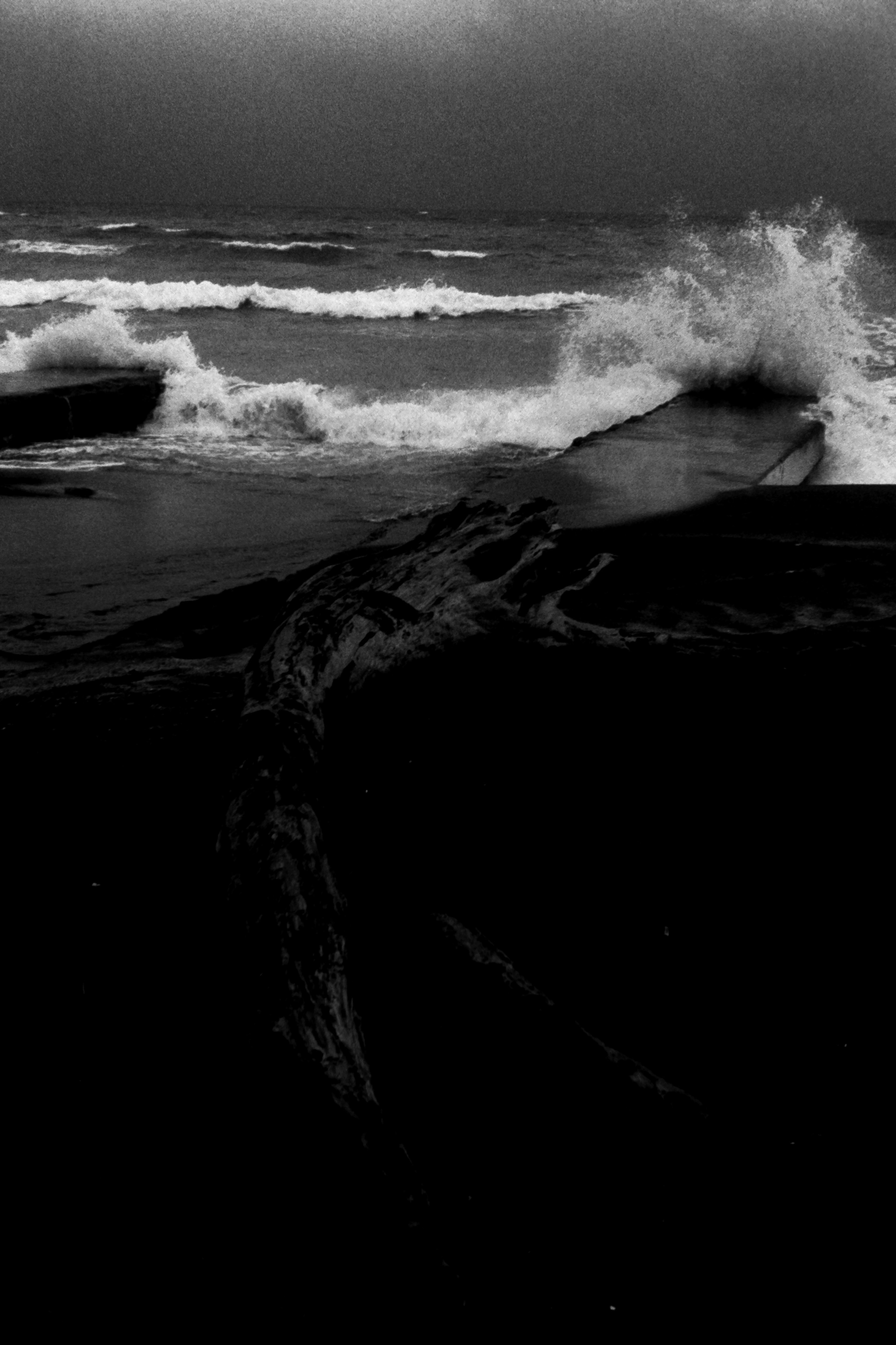 黒と白の海の波が打ち寄せる風景